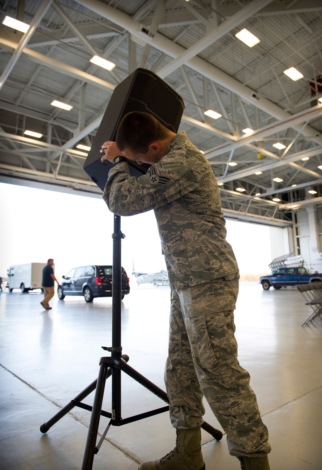 Senior Airman Jeremy Minerich, 1st Special Operations Communications Squadron radio frequency systems technician, setsup speakers for an awards ceremony at the Freedom Hangar on Hurlburt Field, Fla., Dec. 16, 2014. Some 1st SOCS Airmen are charged with an additional duty to setup audio systems for public address at base functions. (U.S. Air Force photo/Senior Airman Krystal M. Garrett) 