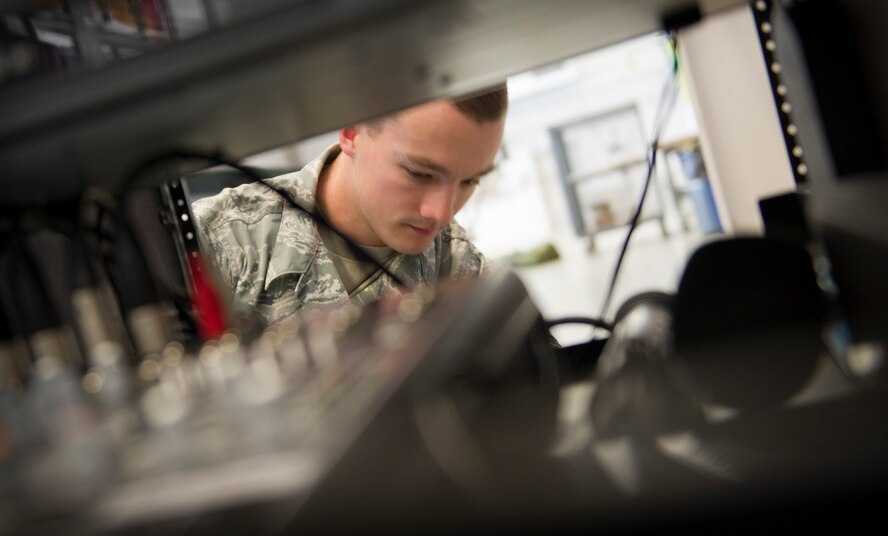 Senior Airman Jeremy Minerich, 1st Special Operations Communications Squadron radio frequency systems technician, setsup an audio system for an awards ceremony at the Freedom Hangar on Hurlburt Field, Fla., Dec. 16, 2014. 1st SOCS Airmen provide audio support for different ceremonies and events on base. (U.S. Air Force photo/Senior Airman Krystal M. Garrett)