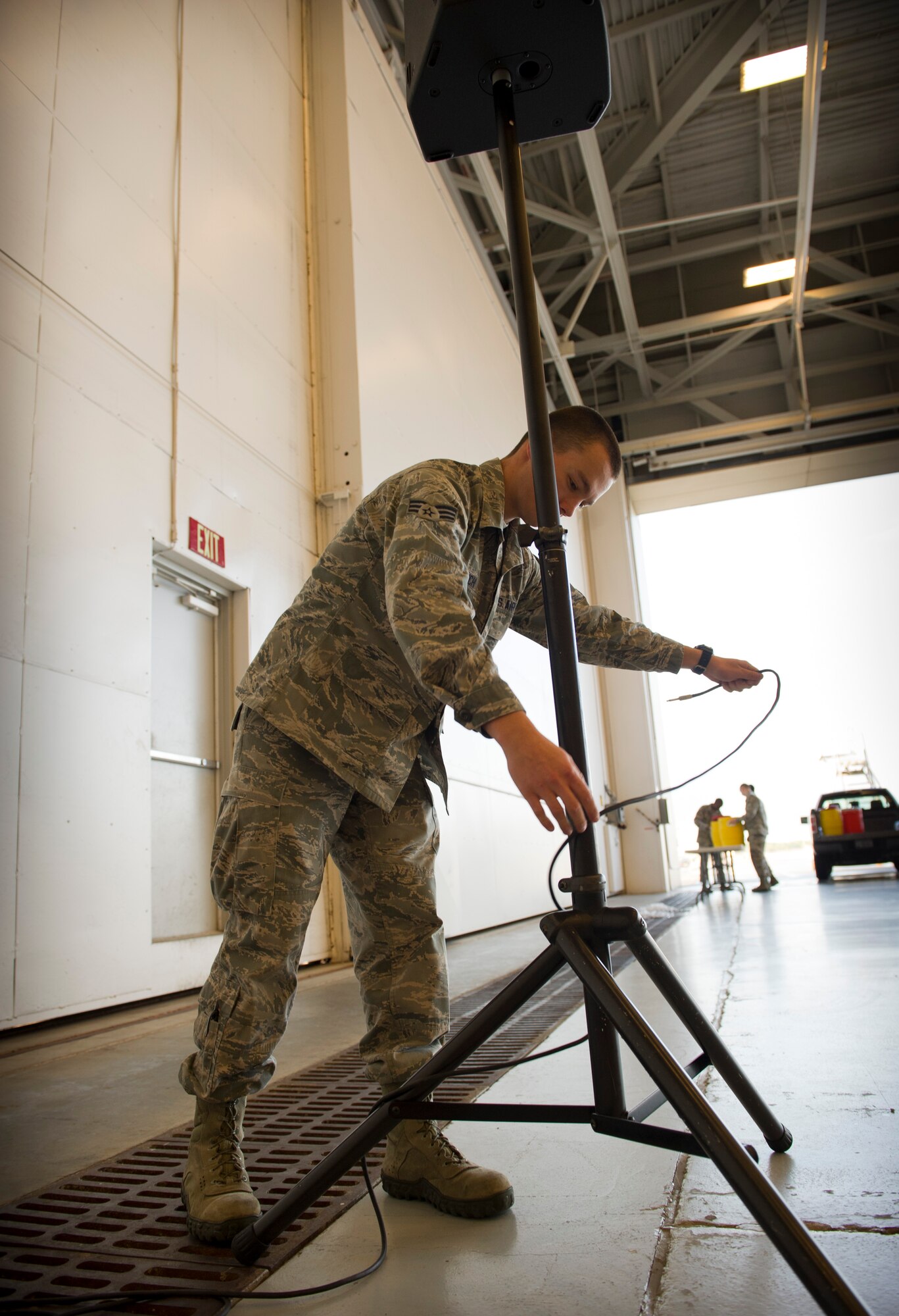 Senior Airman Jeremy Minerich, 1st Special Operations Squdron Communications radio frequency transmission systems technician, organizes cords while setting up speakers for an awards ceremony at the Freedom Hangar on Hurlburt Field, Fla., Dec. 16, 2014. The 1st SOCS supports the global warfighting readiness mission by providing a full spectrum of communications viacomputers and radios. (U.S. Air Force photo/Senior Airman Krystal M. Garrett)