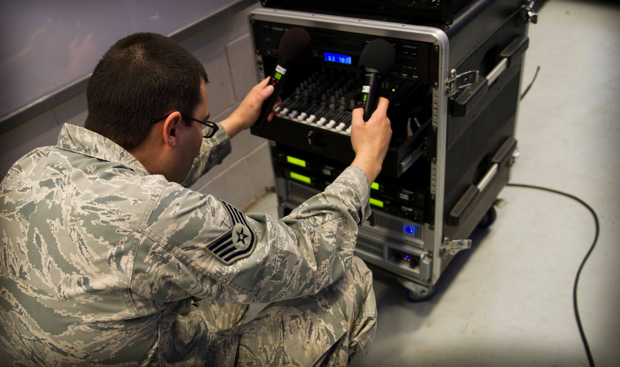 Staff Sgt. Erik Meza, 1st Special Operations Communications Squadron radio frequency transmission technician supervisor, setsup a public address system controller for an awards ceremony at the Freedom Hangar on Hurlburt Field, Fla., Dec. 16, 2014. Some 1st SOCS Airmen are charged with an additional duty to setup audio systems for public address at base functions. (U.S. Air Force photo/Senior Airman Krystal M. Garrett)