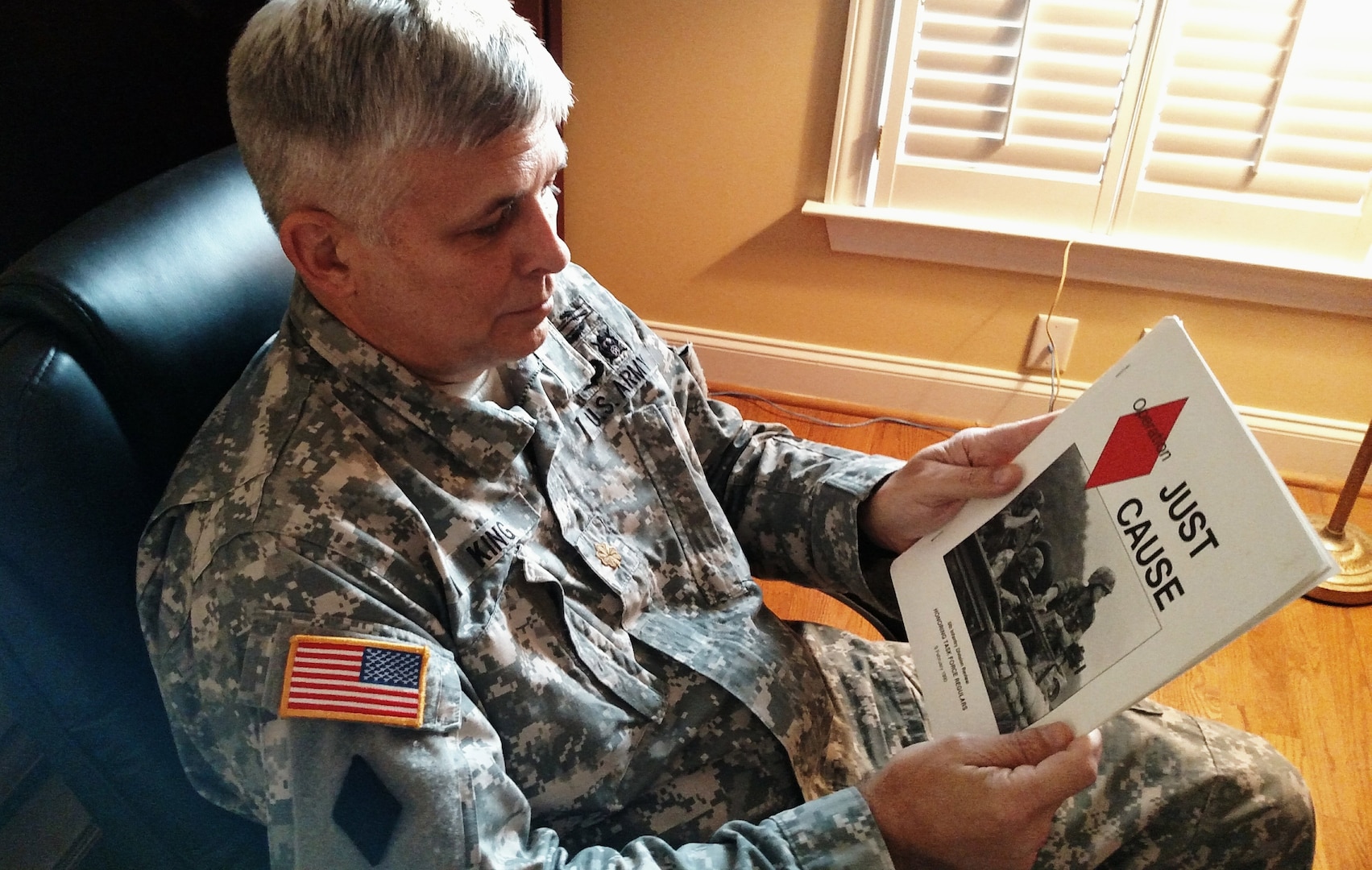 Maj. Dave King, State Partnership Program director for the S.C. Army National Guard, looks through a homecoming parade program from Operation Just Cause, Dec. 18, 2014, Columbia, S.C. King was a junior officer serving in the 4-6th Infantry battalion, 5th Infantry Division (Mechanized) in Fort Polk, Louisiana, when his unit was deployed to Operation Just Cause in Panama in December of 1989. 