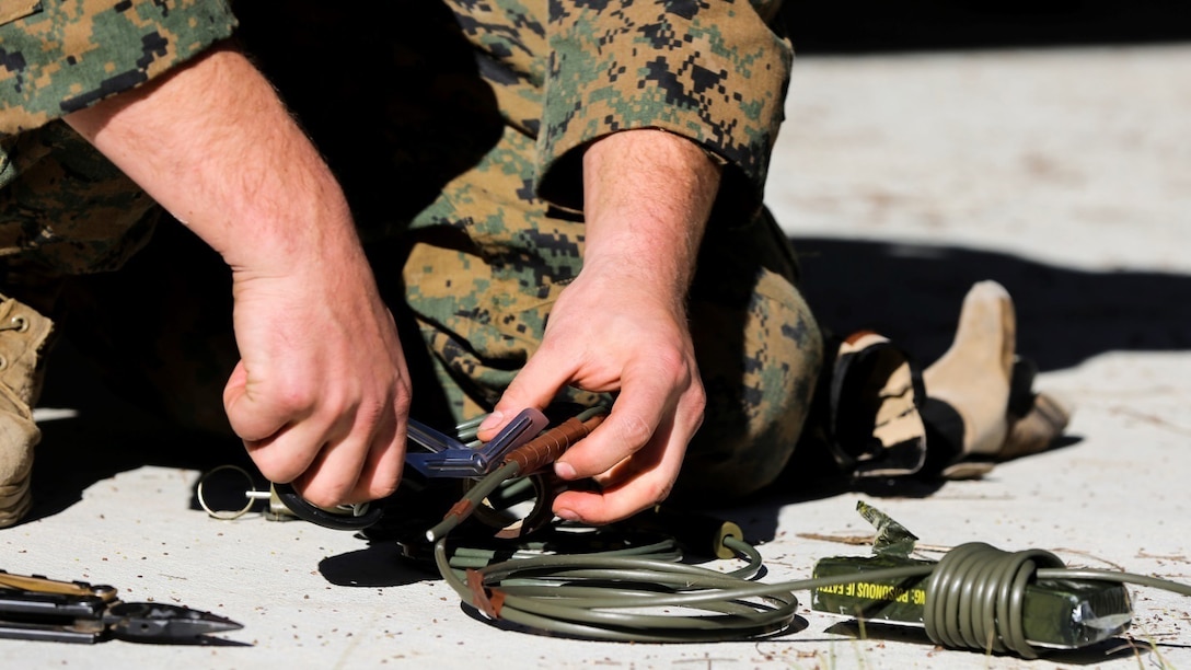 An explosive ordnance disposal technician with Explosive Ordnance Disposal Company, 8th Engineer Support Battalion prepares an explosive during a field exercise Dec. 14, 2014, at EOD site 3 on Camp, Lejeune, N.C. Marines used this method to eliminate a simulated improvised explosive device.