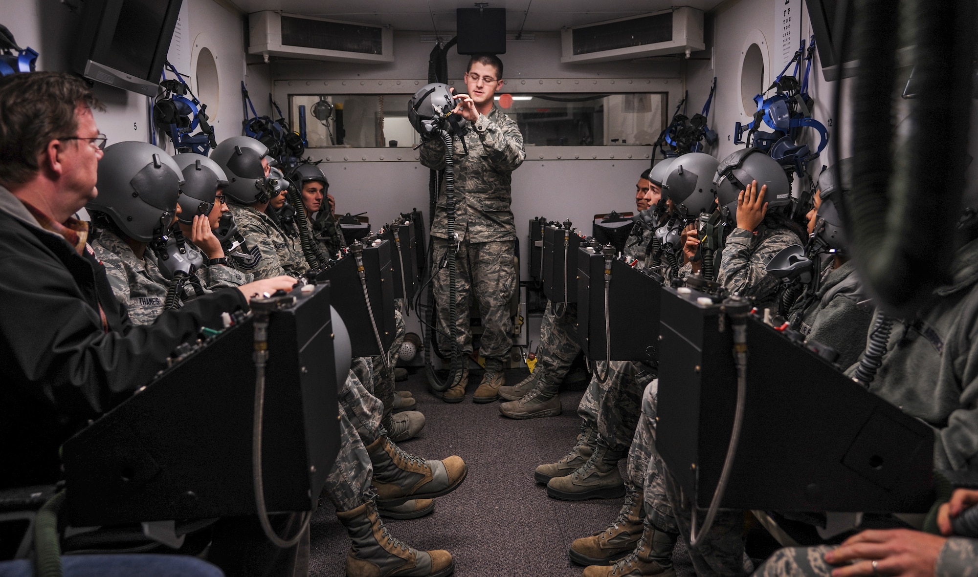 Senior Airman Devin Theis instructs Airmen on the proper use of an oxygen mask during altitude training Dec. 8, 2014, at Little Rock Air Force Base, Ark. Students undergo hypobaric chamber training to experience the effects high altitude has on the body, which include low oxygen levels. Theis is a 19th Aerospace Medicine Squadron high altitude airdrop missions technician. (U.S. Air Force photo/Airman 1st Class Harry Brexel)