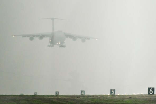 A C-5M Super Galaxy lands on a foggy runway Dec. 10, 2014, at Travis Air Force Base, Calif. The newly modernized aircraft is the fifth C-5M to return to Travis this year following retrograde and refurbishment.  (U.S. Air Force photo/Ken Wright)