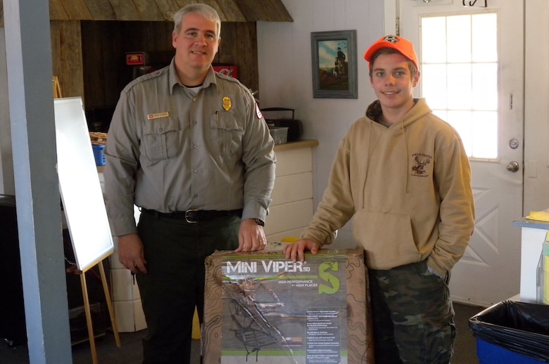Biologist Kenny Claywell, U.S. Army Corps of Engineers Nashville District park ranger at Cordell Hull Lake, presents Noah Likens of Murfreesboro, Tenn., with a Mini Viper Tree Stand donated by Summit Treestands LLC in Birmingham, Ala.  Likens won the tree stand Dec. 7, 2014 after participating in the two-day 2014 Defeated Creek Youth Deer Management Hunt held at Defeated Creek Recreation Area in Carthage, Tenn.