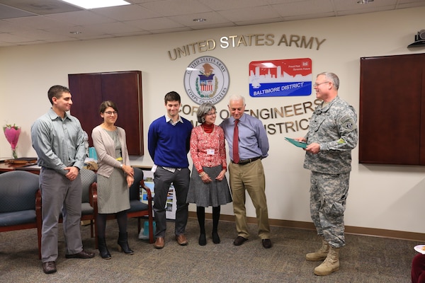 USACE Baltimore chief of operations, receives his retirement certificate from Col. Trey Jordan, USACE Baltimore District commander, after 28 years of federal service alongside his family Dec. 16.