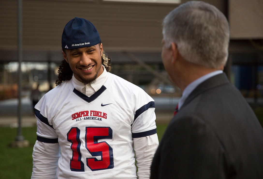 Benning Potoae (left), a defensive end for the Lakes High School Lancers varsity football team and 18-year-old native of Dupont, Washington, speaks with Lakewood Mayor Don Anderson after Potoae received his 2015 Semper Fidelis All-American Bowl jersey from Seattle-area Marines at Lakes High School in Lakewood, Washington, Dec. 16, 2014. Potoae is among approximately 100 student athletes from across the nation selected to participate in the game at the StubHub Center in Carson, Calif., Jan. 4, 2015. He joins cornerback Austin Joyner from Marysville-Pilchuck High School and offensive tackle Shane Lemieux from Yakima’s West Valley High School as the Washington State players selected for the 2015 game. (U.S. Marine Corps photo by Sgt. Reece Lodder)