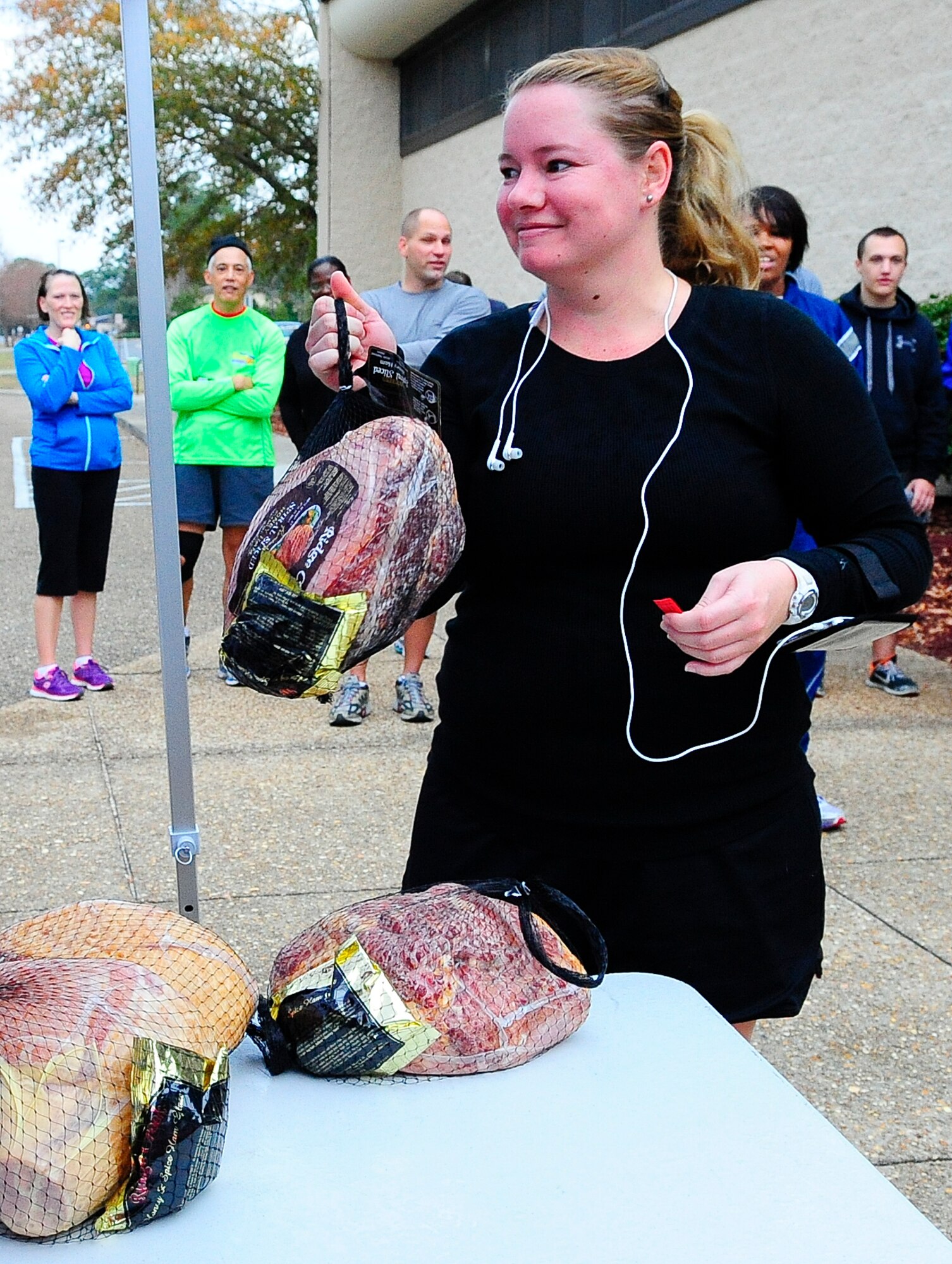 Tech. Sgt. Alanda Repress, 1st Special Operation Support Squadron aviation resource management apprentice, wins a holiday ham during the Jingle Bell 5K Fun Run raffle near the Aderholt Fitness Center on Hurlburt Field, Fla., Dec. 19, 2014. After the race, holiday hams were given out to five lucky participants. (U.S. Air Force photo/Airman 1st Class Andrea Posey)