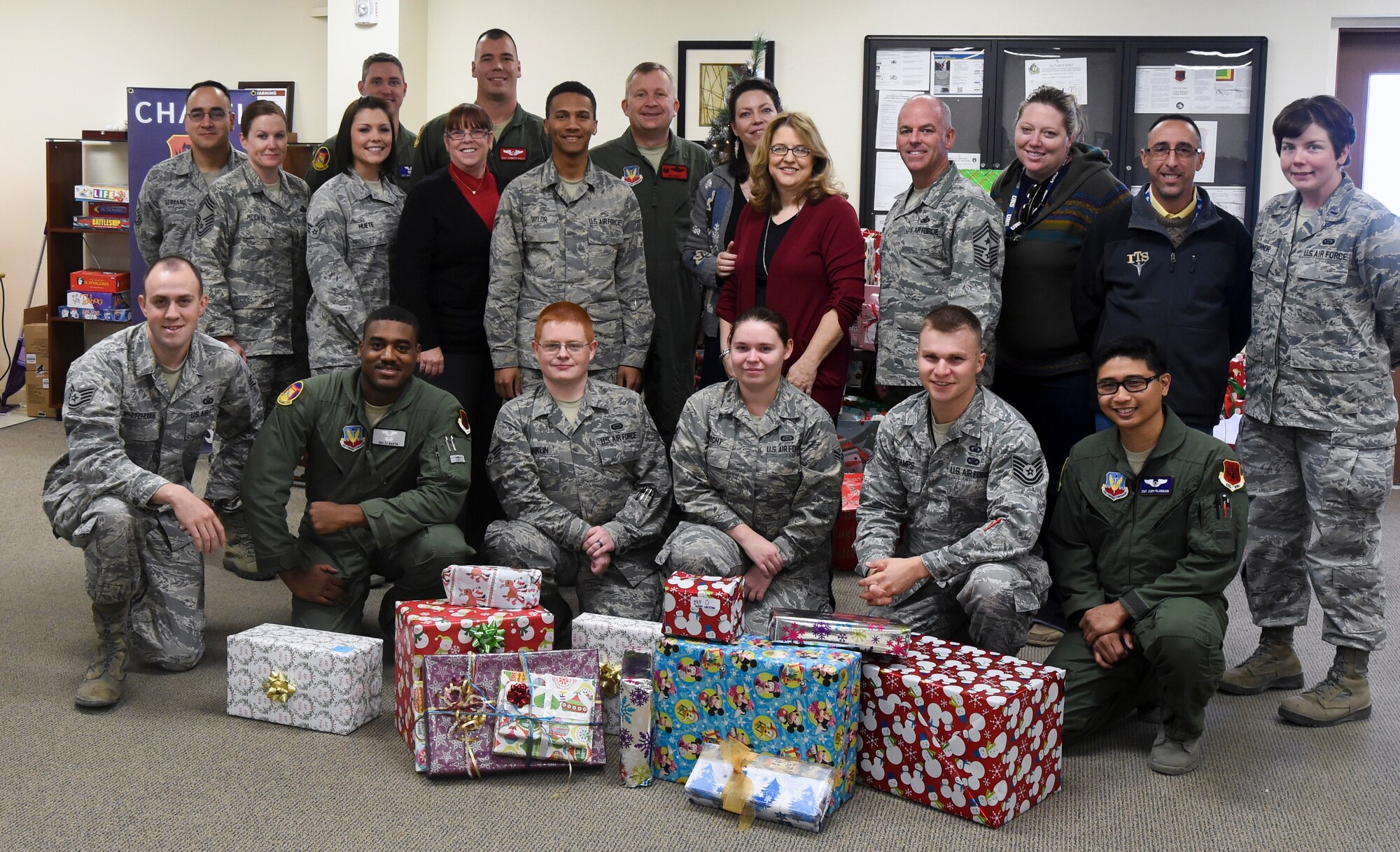 Leadership from the 432nd Wing/432nd Air Expeditionary Wing and Indian Springs school representatives join some of the Airmen who donated more than 300 Christmas presents during the 2014 Holiday Gift Drive open house event at the Airmen Ministry Center at Creech Air Force Base, Nevada, Dec. 16, 2014. Nearly 100 Airmen and civilian Air Force members donated the presents for 110 children who attend Indian Springs elementary, middle or high schools. (U.S. Air Force Photo by Tech. Sgt. Shad Eidson/released)