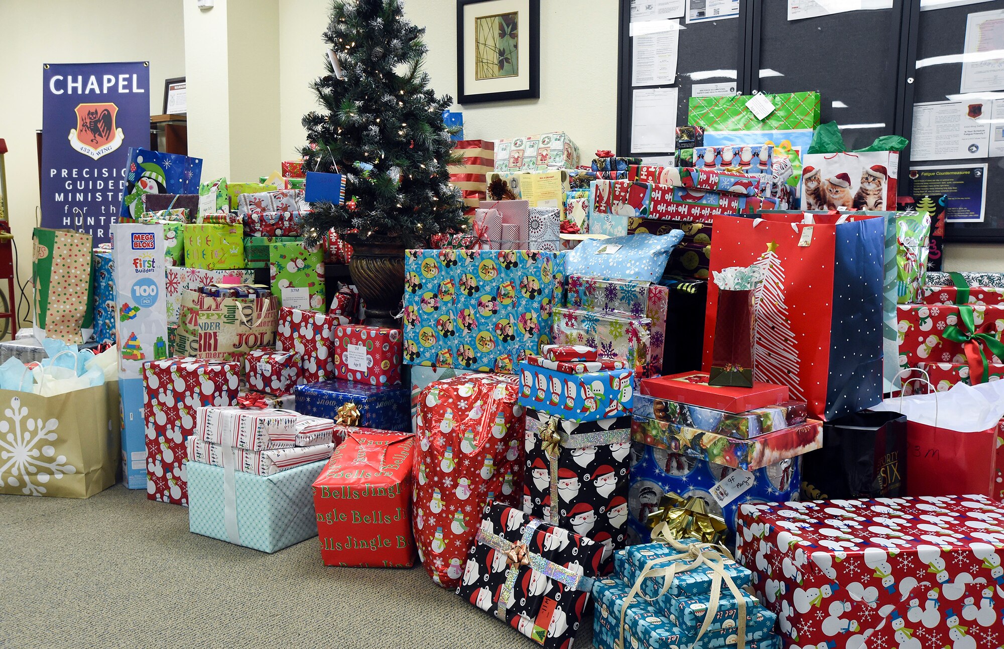 Three hundred Christmas presents are displayed during the 2014 Holiday Gift Drive open house event at the Airman Ministry Center at Creech Air Force Base, Nevada, Dec. 16, 2014. The Creech AFB Chapel hosts the event annually as a way to further partnership with the local community, and this year nearly 100 Airmen and civilian Air Force members donated presents for 110 children who attend Indian Springs schools. (U.S. Air Force Photo by Tech. Sgt. Shad Eidson/released)