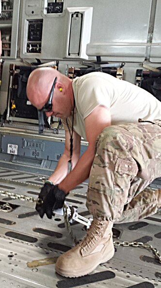 Master Sgt. Gregory Abel, deployed to Dakar, Senegal from the 86th Aerial Port Squadron at Joint Base Lewis-McChord, Washington, ties down some cargo being airlifted in support of Operation United Assistance.  (Courtesy photo)