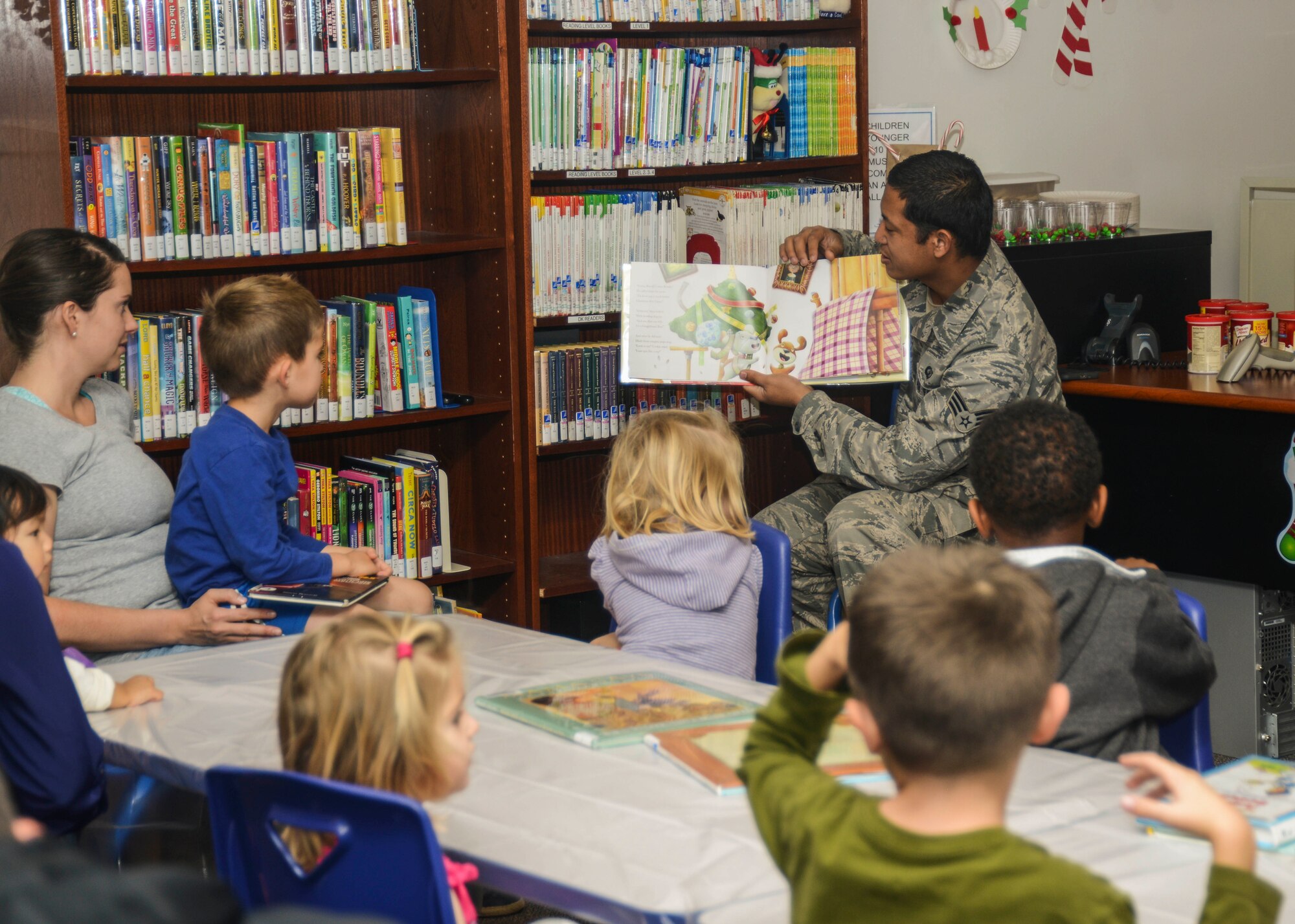 Senior Airman Jerome Bayona, 412th Operation Support Squadron, read "A Cookie for Santa." (U.S. Air Force photo by Rebecca Amber)
