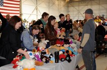Senior Master Sgt. Jason Davis (right), hands out stuffed animals to members of Team Beale during the  annual Children's Holiday Party at Beale Air Force Base, Calif., Dec. 13, 2014. More than 1,000 members of Team Beale attended the event. (U.S. Air Force photo by Staff Sgt. Robert M. Trujillo/Released)