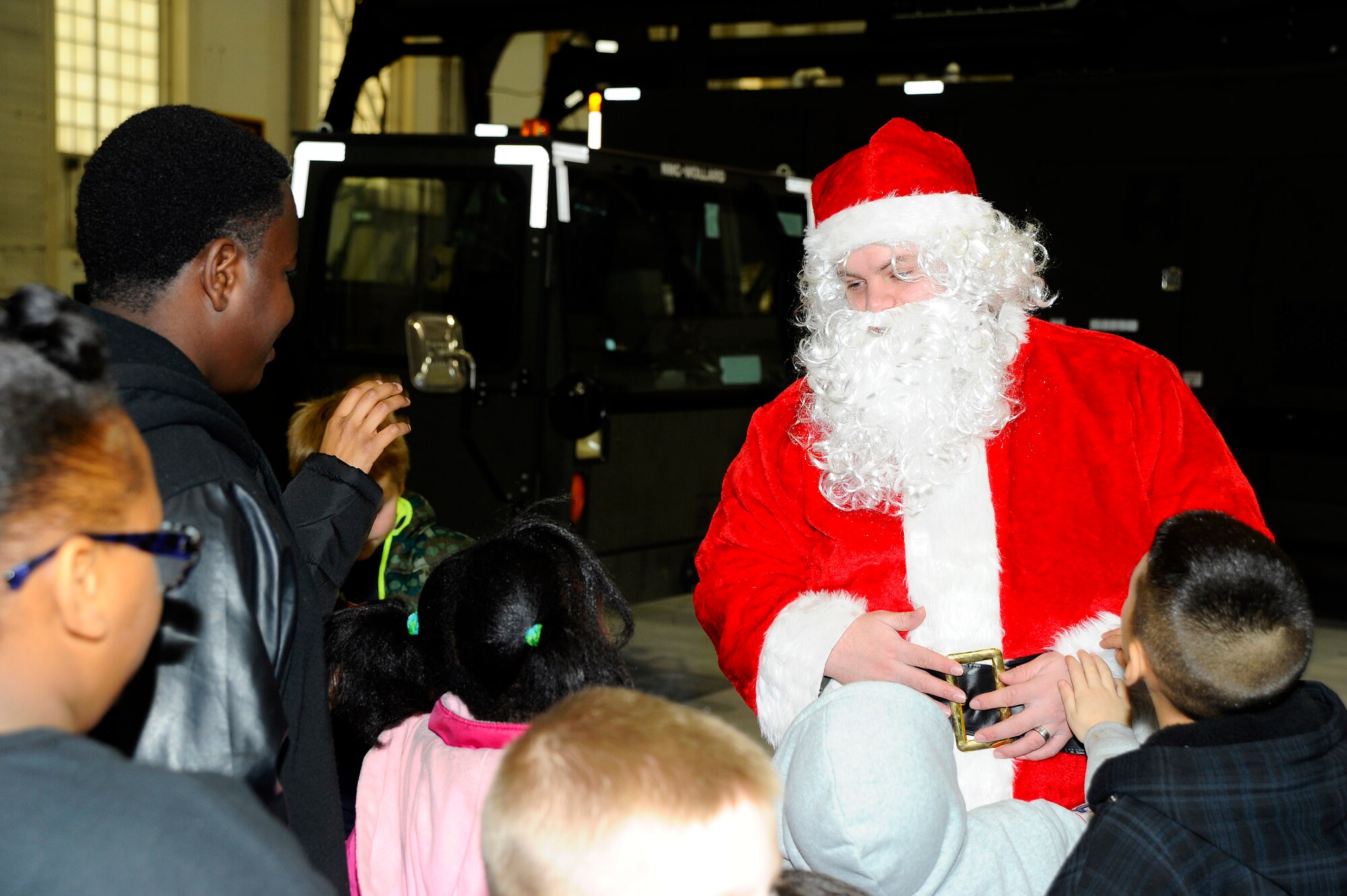 Santa greets children from Big Brothers Big Sisters Wichita, Dec. 19, 2014, at McConnell Air Force Base, Kan. The children were given a tour of the base that included visits to the fire department, the KC-135R Stratotanker flight simulator and ended with Santa bringing along some surprise gifts. (U.S. Air Force photo/Senior Airman Victor J. Caputo)