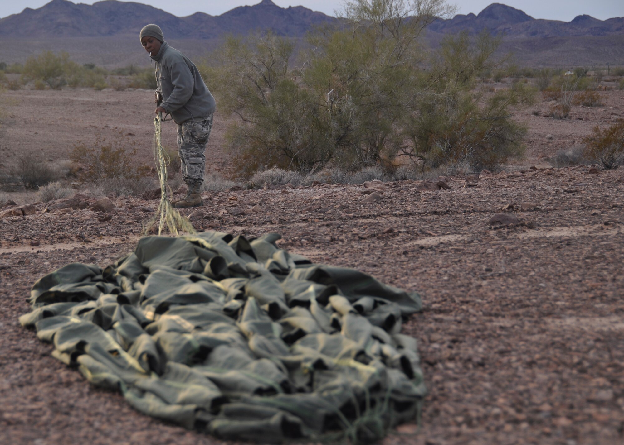 Staff Sgt. Latresha Peterson, member of the 80th Aerial Port Squadron, untangles a parachute from a pallet at Yuma, Arizona, Dec. 15, 2014. The pallet was dropped from a C-130 at an altitude of 18,000 feet. (U.S. Air Force photo by SrA Miles Wilson)