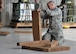 Tech. Sgt. Jeremy Wetherington, member of the 80th Aerial Port Squadron, cuts strips of honeycomb cardboard to place under pallets at Yuma, Arizona, Dec. 15, 2014. The pallets were to be airdropped from C-130's during Desert University Training. (U.S. Air Force Photo by Senior Airman Miles Wilson)