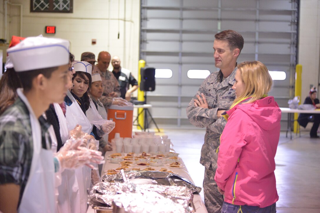 Col. Tom Miller, 377th Air Base Wing commander, and his wife, Kim, check out the serving line at the Operation Holiday Cheer event Dec. 17. Lunch was served to about 2,000 people from local communities, and more than 800 toys were given away to kids. Operation Holiday Cheer is sponsored by the Kirtland Fire Department and is one of the base's biggest charity events of the year. (Photo by Todd Berenger)