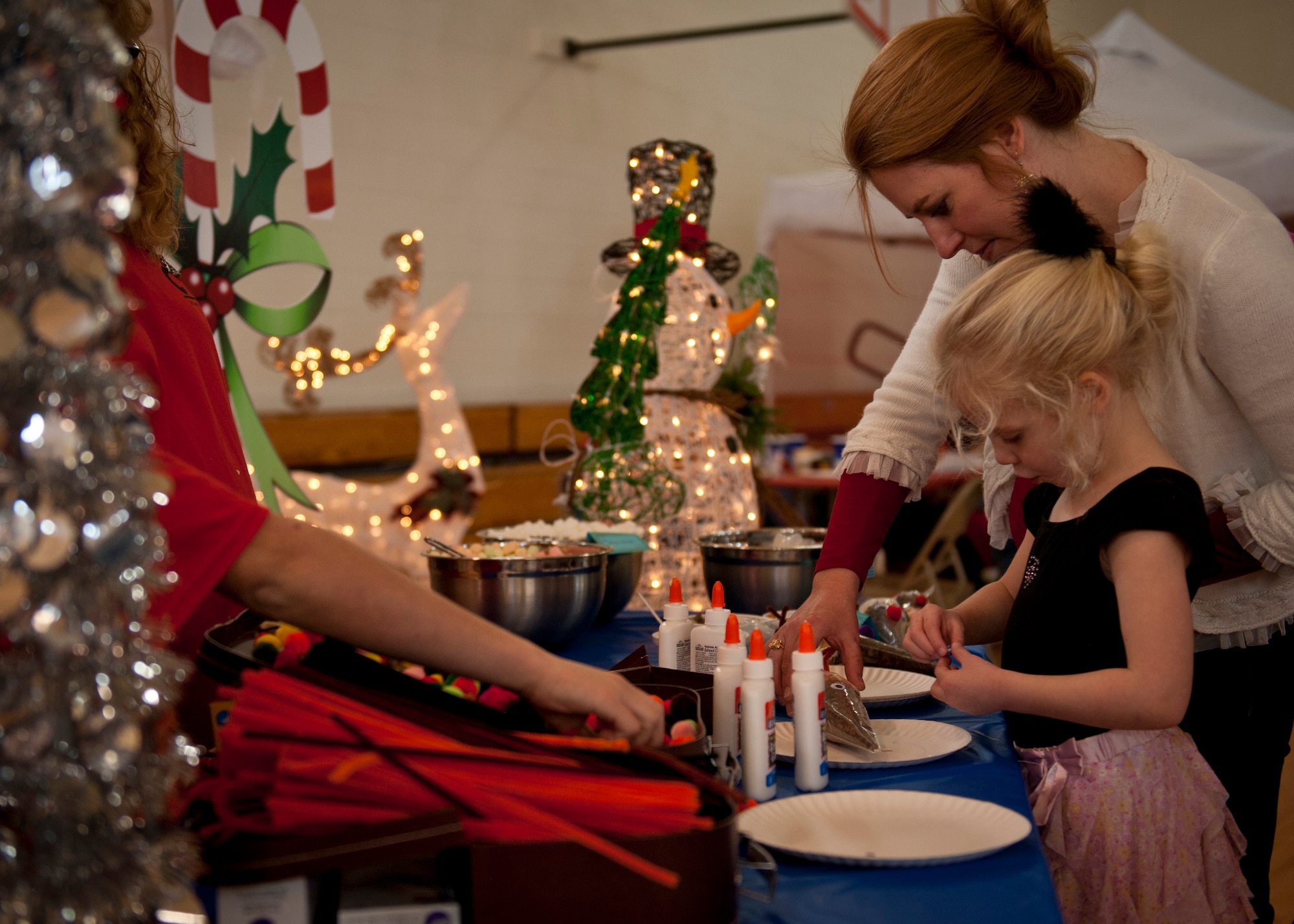PETERSON AIR FORCE BASE, Colo. – Lylah Hill, 4, gets help from her mom to glue eyes on her reindeer at the Winter Wonderland event held at the R. P. Youth Center, Dec. 13, 2014. The second annual Winter Wonderland was held to celebrate the beginning of the winter season and the holidays with crafts, face painting, snacks, Santa and much more. (U.S. Air Force photo by Airman 1st Class Rose Gudex)