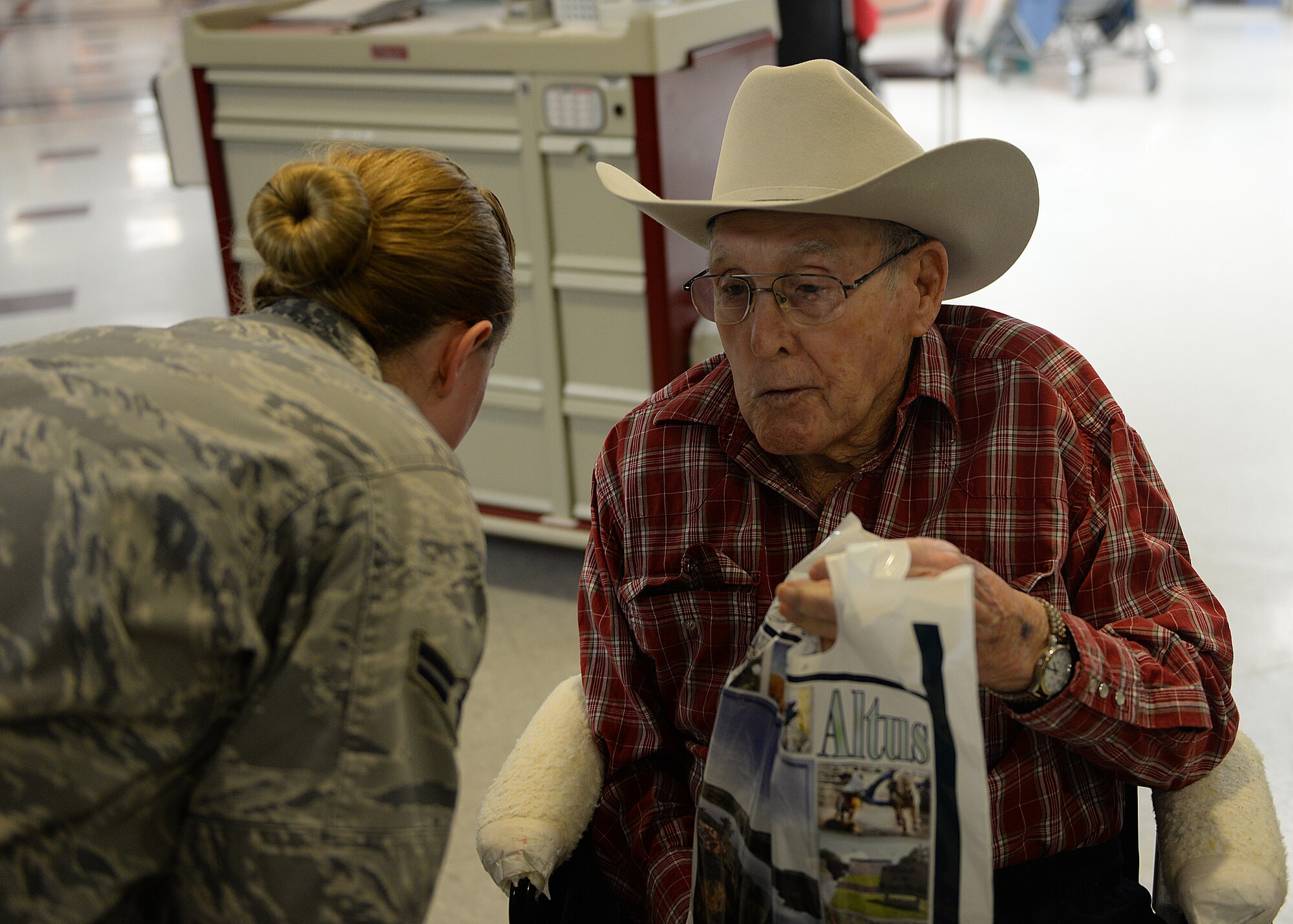 CLINTON, Okla. – An Airman leans down to better hear a veteran after handing him a present during a volunteer trip to the Oklahoma Veteran’s Center, Dec. 17, 2014. The veterans were happy to be visited by the Airmen, excited more for the company than the gifts, and spent as much time as they could telling their stories to the younger generation. (U.S. Air Force photo by Airman 1st Class Megan E. Acs/Released)