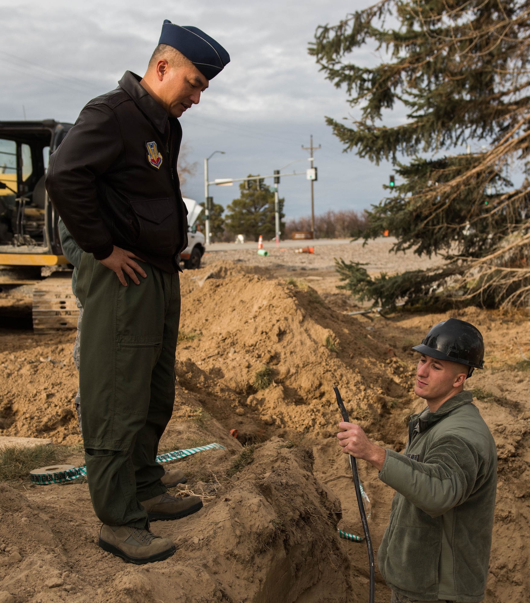 Col. Sarady Tan, 366th Medical Group commander, and Airman 1st Class Zachary Kepp, 366th Communications Squadron cable antenna systems personnel, discuss a severed fiber optic cable Dec. 18, 2014, at Mountain Home Air Force Base, Idaho. The damaged cable shut down all communications for the MDG. (U.S. Air Force photo by Airman Connor J. Marth/RELEASED)