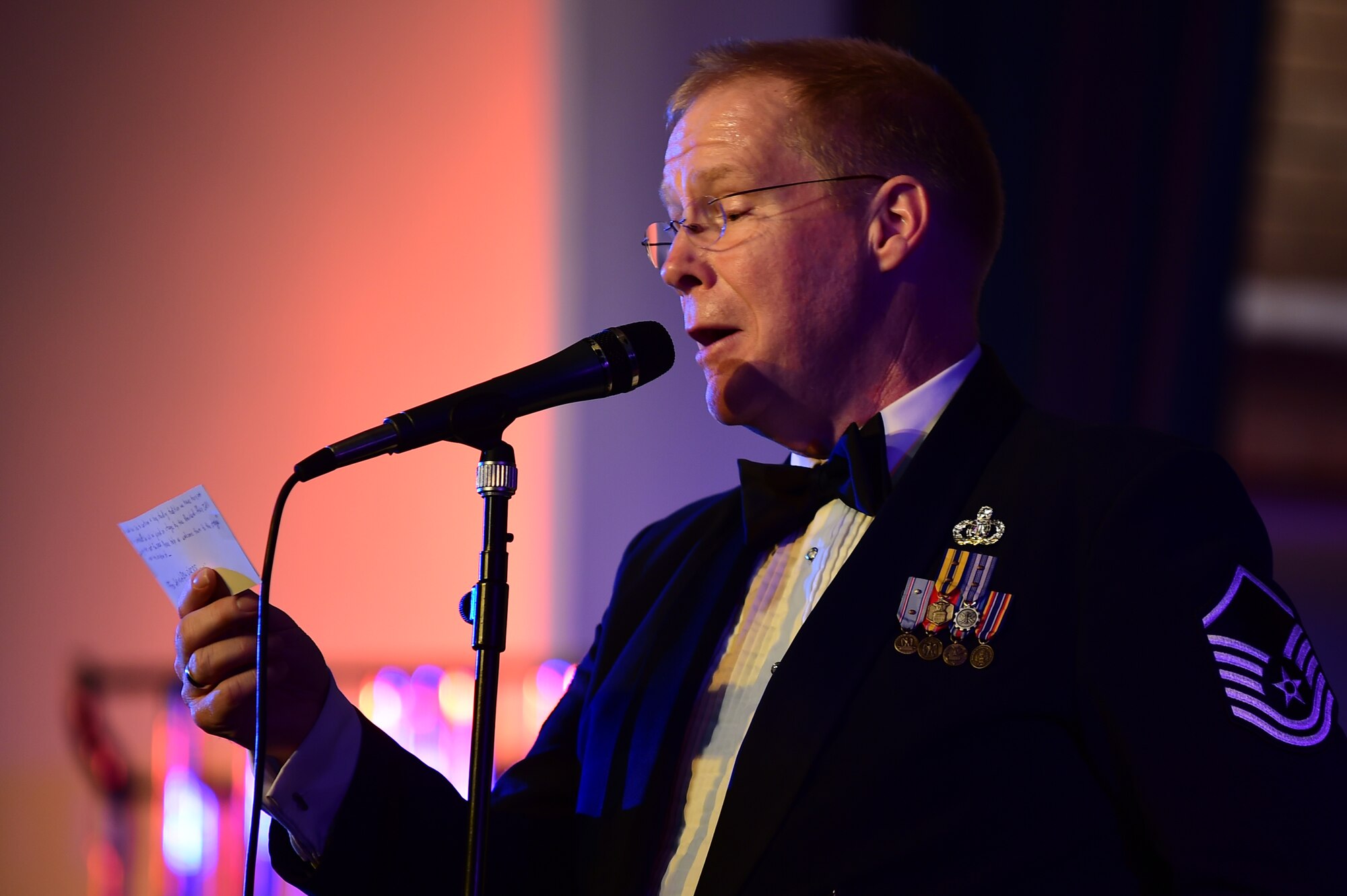 Master Sgt. Steven Schaughency emcees the U.S. Air Forces in Europe Concert band performance during   the holiday celebration at Burgess Hall in St. Ives, Cambridgeshire, England, Dec. 18, 2014. (U.S. Air Force photo by Tech. Sgt. Chrissy Best)