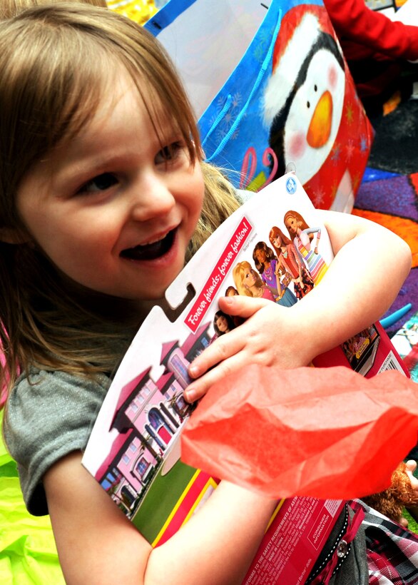 A child holds onto her gift at the Youth & Family Services Child Development Center in Rapid City, S.D., Dec. 16, 2014. (U.S. Air Force photo by Senior Airman Hailey R. Staker/Released)