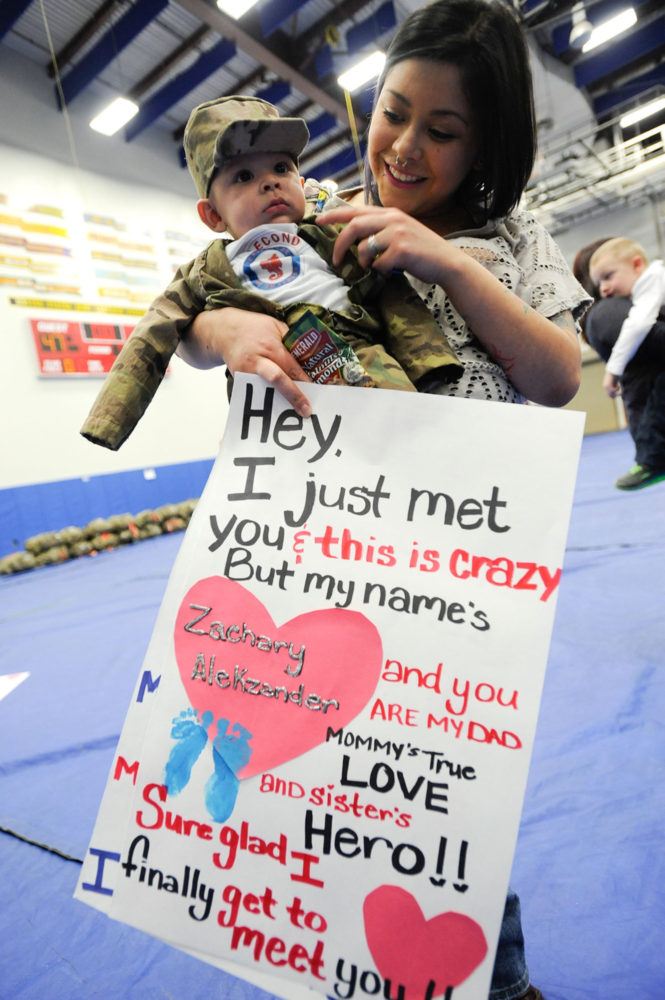 Angela Castruita and Zachary Alekzander, three months old, wait for Sgt. Jacob Castruita in Buckner Physical Fitness Center at Joint Base Elmendorf-Richardson, Alaska, Dec. 14, 2014. Castuita, along with the rest of the 2d Engineer Brigade Headquarters, came home after nine months on deployment in Afghanistan. (U.S. Air Force photo/Staff Sgt. Robert Barnett)