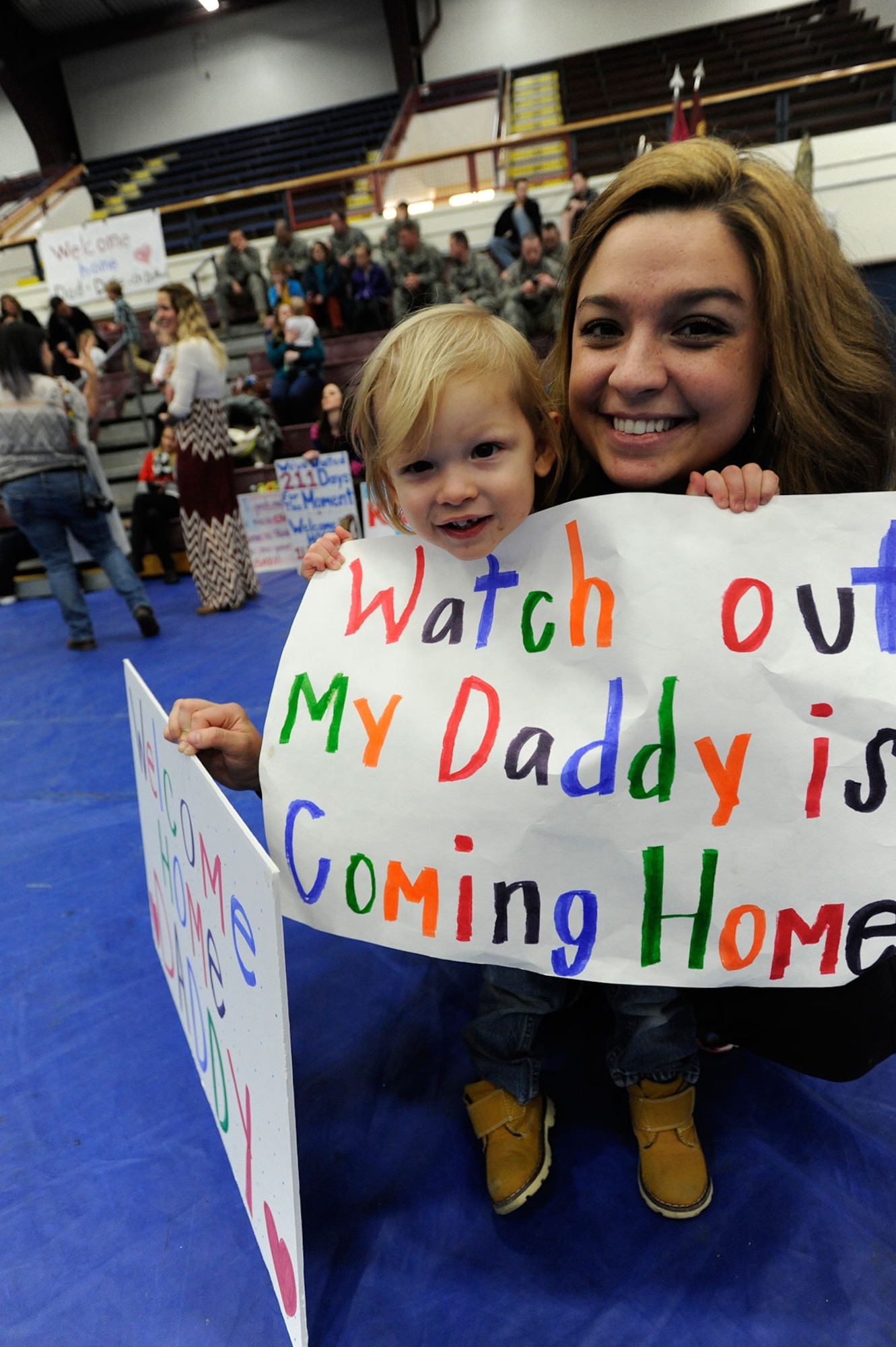 Samantha Graziosi and her son, Titus, 23 months old, wait in Buckner Physical Fitness Center at Joint Base Elmendorf-Richardson, Alaska, for their husband and father to return from deployment Dec. 14, 2014. Titus has been waiting to get his first haircut until his father came home. Spc. Charles Graziosi is a member of the 2d Engineer Brigade Headquarters that deployed to Afghanistan for nine months. (U.S. Air Force photo/Staff Sgt. Robert Barnett)