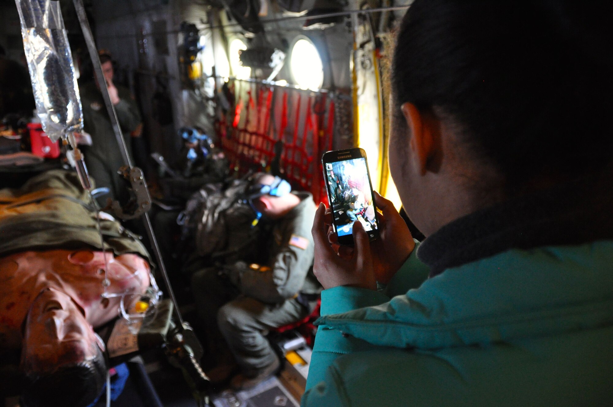 Asia Boyd-Davis, a trainee with the 911th Development and Training Flight, snaps a photo on her phone to take home a memory of her first flight on military aircraft during an aero-medical training flight, Dec. 7, 2014. Typically twice a year trainees that are apart of the DTF take part on a training flight aboard C-130 Hercules aircraft to give them a full spectrum experience of what the Air Force Reserve is all about before heading off to U.S. Air Force Basic Military Training. (U.S. Air Force photo by Senior Airman Joseph E. Bridge)