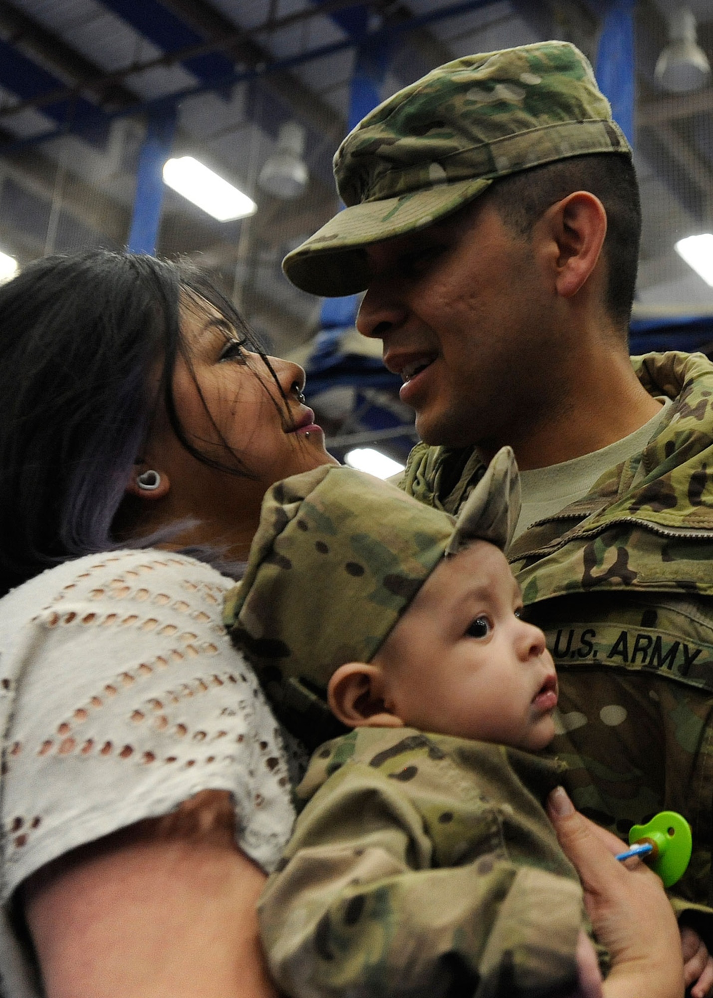 Angela Castruita greets her husband, Sgt. Jabon Castuita, with Zachary Alekzander, three months old, in Buckner Physical Fitness Center at Joint Base Elmendorf-Richardson, Alaska, Dec. 14, 2014. Castuita, along with the rest of the 2d Engineer Brigade Headquarters, came home after nine months on deployment in Afghanistan. (U.S. Air Force photo/Staff Sgt. Robert Barnett)