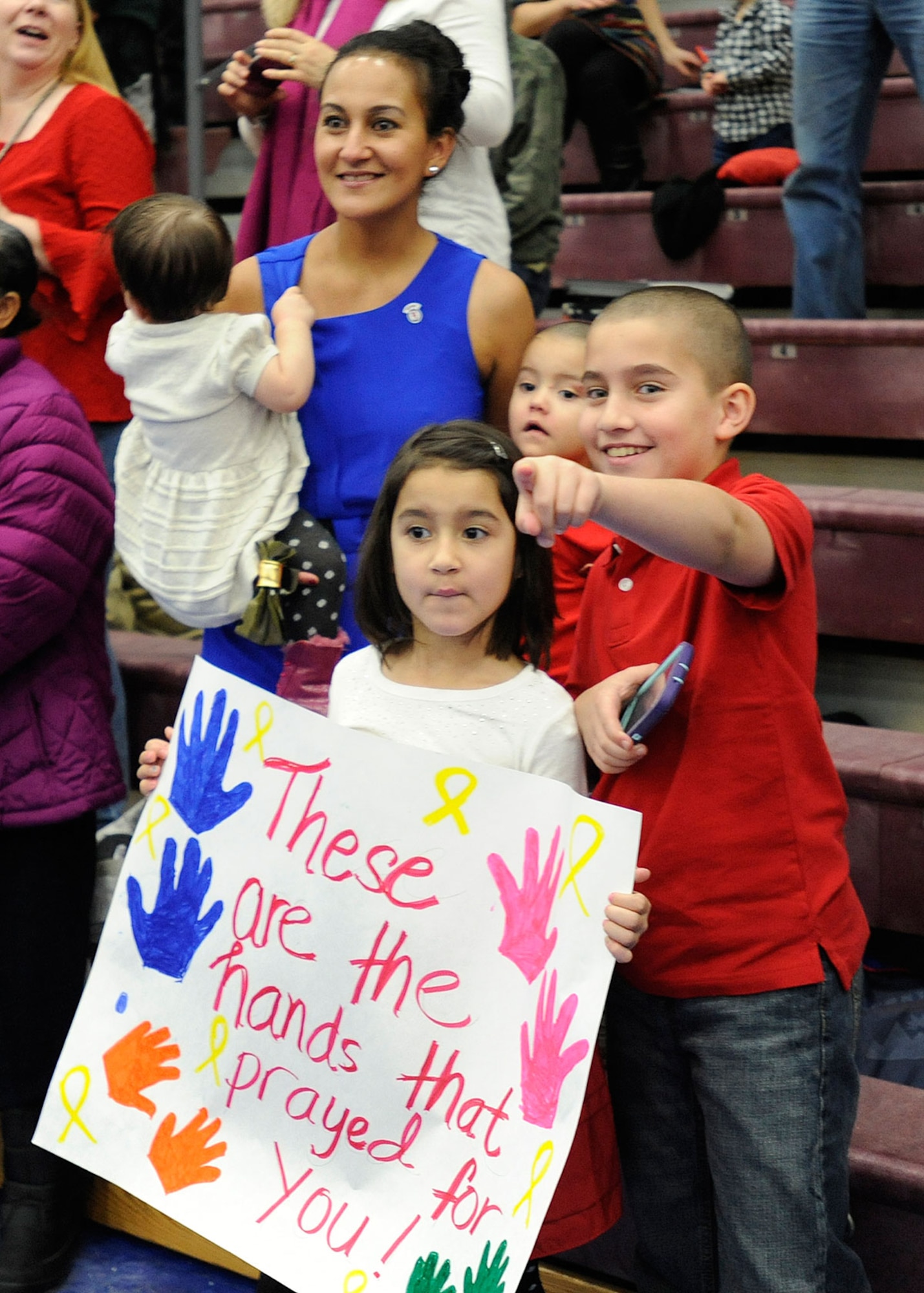 Friends and families wait for the return of their loved ones at Joint Base Elmendorf-Richardson, Alaska, Dec. 14, 2014. Many made signs and put up decorations like American flags to greet their military sponsers home from deployment in Afghanistan. (U.S. Air Force photo/Staff Sgt. Robert Barnett)