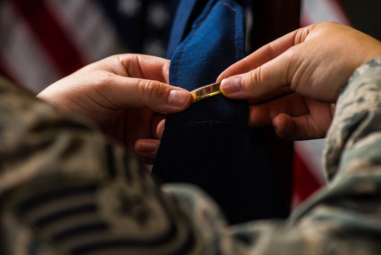 An enlisted Airman prepares his dress blues for the first time as an Air Force officer. To bear the title of a commissioned leader, Airmen must face multiple challenges in Officer Training School. (U.S. Air Force photo by Airman Connor J. Marth/RELEASED)
