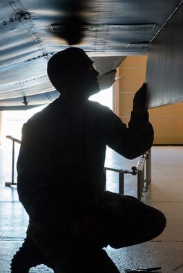 U.S. Air Force Tech. Sgt. Curtis Lasher, 23d Equipment Maintenance Squadron crew chief, checks the inboard landing gear door to ensure it was properly installed during an isochronal inspection Dec. 10, 2014, at Moody Air Force Base, Ga. Lasher replaced the cracked door during the fix phase of the ISO inspection. (U.S. Air Force photo by Airman 1st Class Ceaira Tinsley)