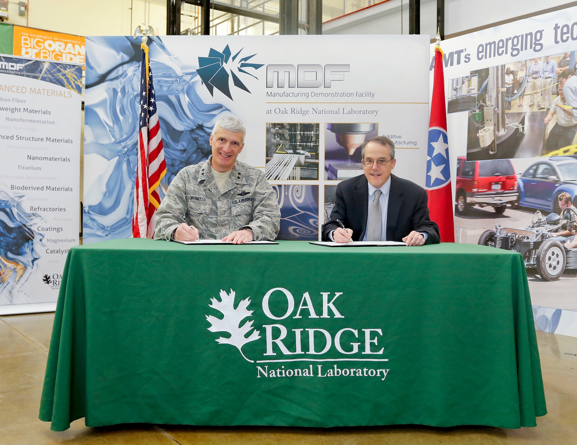 Maj. Gen. Tom Masiello, Air Force Research Laboratory commander, and Dr. Jim Roberto, Department of Energy Oak Ridge National Laboratory Associate Laboratory Director for Science and Technology Partnerships, sign a Memorandum of Understanding during an event Dec. 16 in Roane County, Tenn. The MOU between the labs intends to improve the cost, schedule and performance associated with developing critical technologies that will transition to armed forces units. (Oak Ridge National Laboratory photo by Jason Richards)