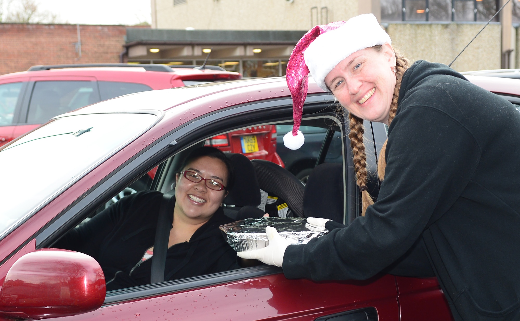 Bobbie Mach, right, wife of U.S. Air Force Lt. Col. Timothy Mach, 100th Operation Support Squadron director of operations from Cleveland, receives a cookie donation from a Team Mildenhall member Dec. 15, 2014, on RAF Mildenhall, England. The cookie donations were packed and distributed to Airmen in the dorms by Team Mildenhall leadership. (U.S. Air Force photo by Airman 1st Class Jonathan Light/Released) 
