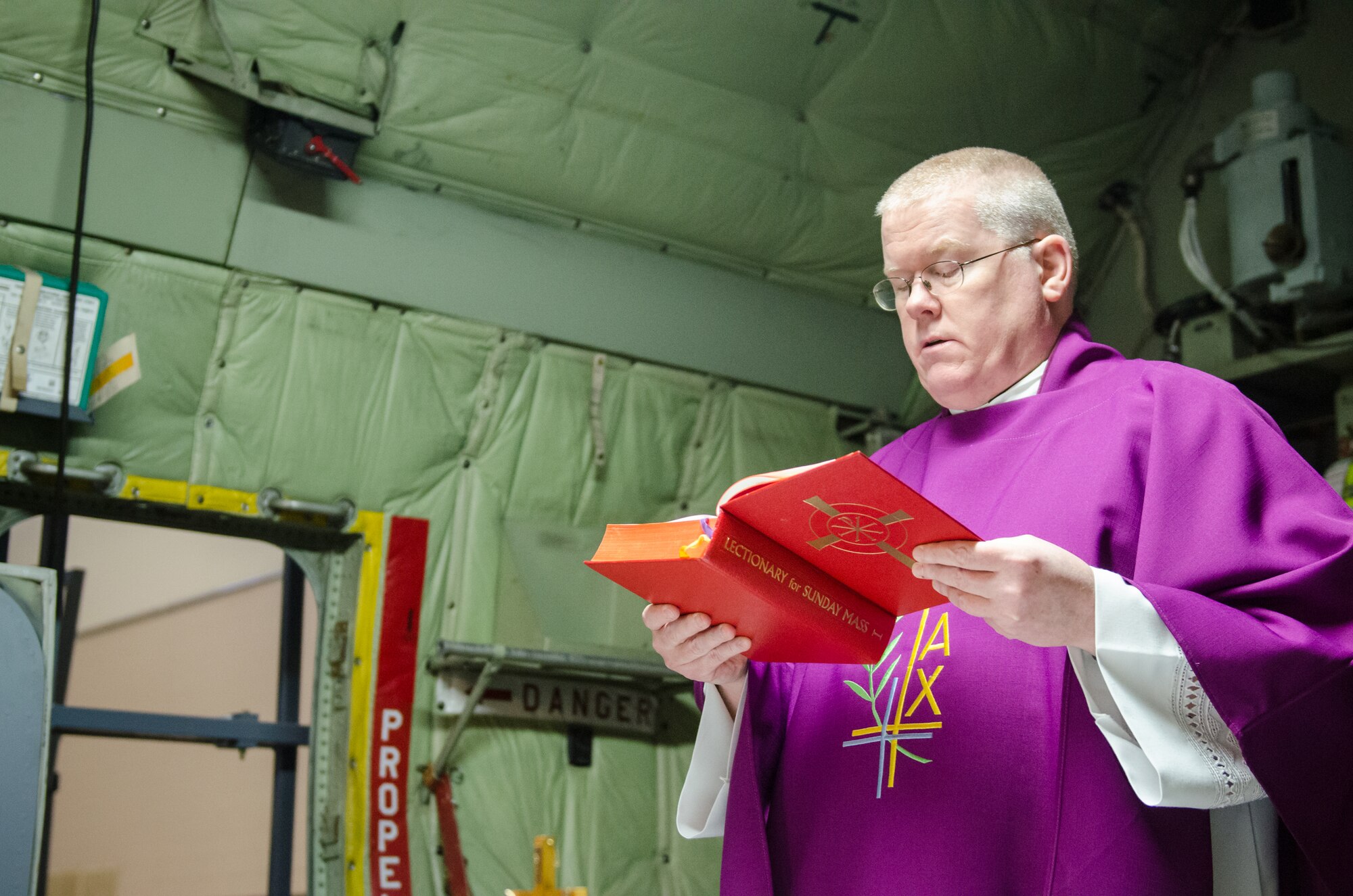 Chaplain (Lt. Col.) Patrick Cooney celebrates his final Mass as Catholic chaplain for the 123rd Airlift Wing at the Kentucky Air National Guard Base in Louisville, Ky., Dec. 7, 2014. Cooney retired from military service the same day, concluding a career of more than 30 years in the active-duty Air Force and Air National Guard. (U.S. Air National Guard photo by Senior Airman Joshua Horton)