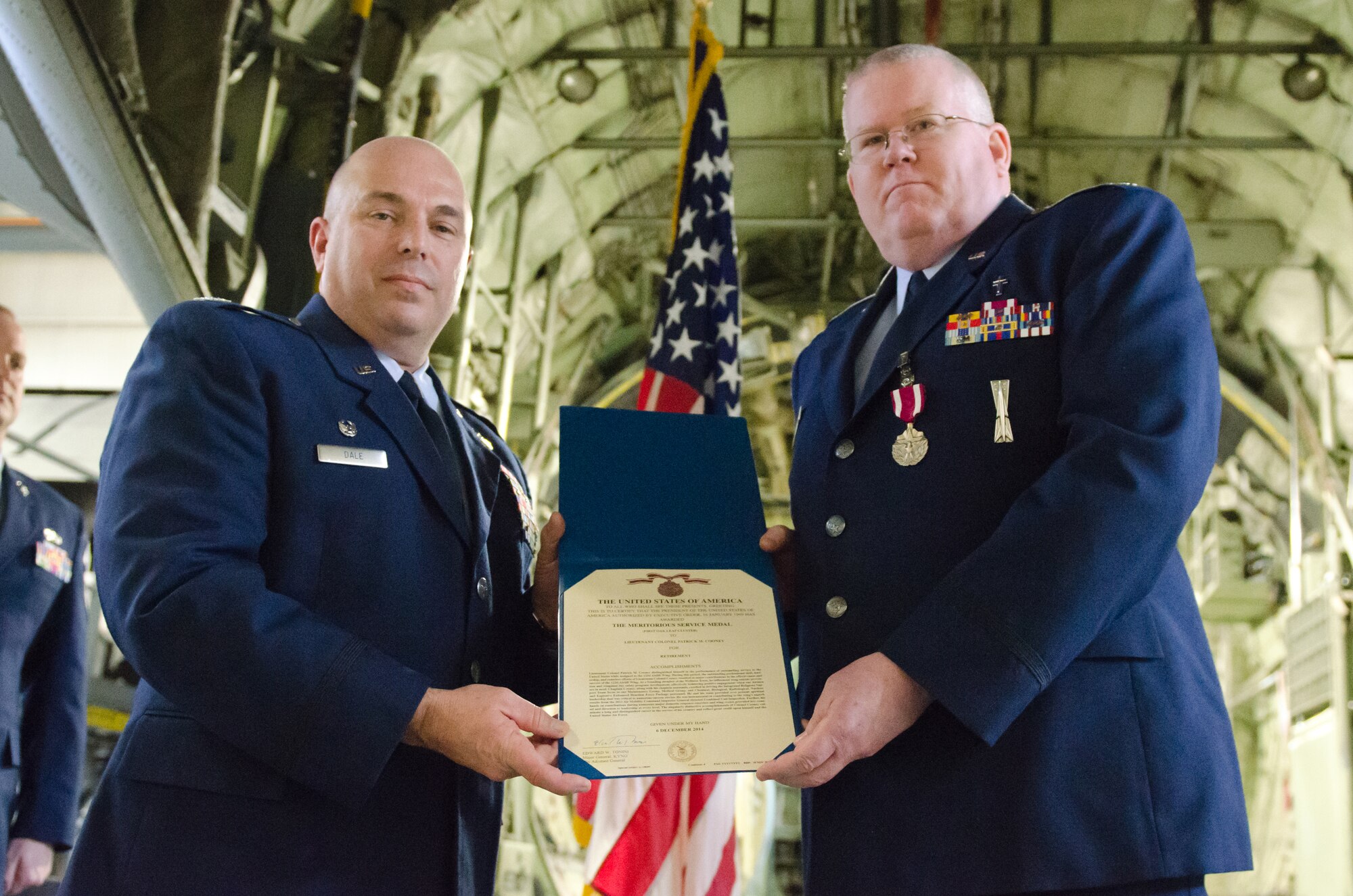 Col. Ken Dale (left), commander of the 123rd Airlift Wing, presents Chaplain (Lt. Col.) Patrick Cooney, the Kentucky Air National Guard’s Catholic and wing chaplain, with the Meritorious Service Medal during Cooney’s retirement ceremony at the Kentucky Air National Guard Base in Louisville, Ky., on Dec. 7, 2014. Cooney is retiring after more than 30 years of service to the active-duty Air Force and Air National Guard. (U.S. Air National Guard photo by Senior Airman Joshua Horton)