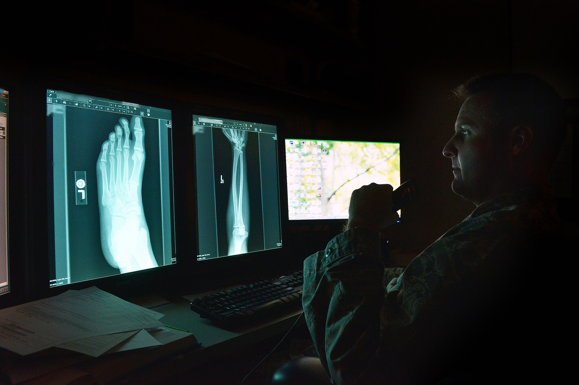 Lieutenant Colonel David Ives, 31st Surgical Operations Squadron radiologist, takes notes using a dictation machine while reviewing x-rays, Dec. 16, 2014, at Aviano Air Base, Italy. The 31 SGC radiology team is made up of eight enlisted diagnostic technicians and one doctor who specializes using imaging to diagnose and treat diseases seen within the body. (U.S. Air Force photo/Airman 1st Class Ryan Conroy) 