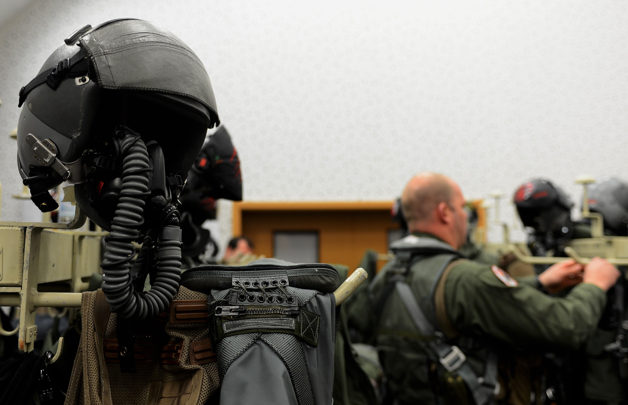 A fighter pilot’s helmet and gear rests in an equipment room at Spangdahlem Air Base, Germany, Dec. 17, 2014. Fighter pilots from Royal Air Force Lakenheath, England; Aviano Air Base, Italy; and Spangdahlem joined together to participate in exercise Iron Hand 15-2. (U.S. Air Force photo by Airman 1st Class Luke Kitterman/Released)