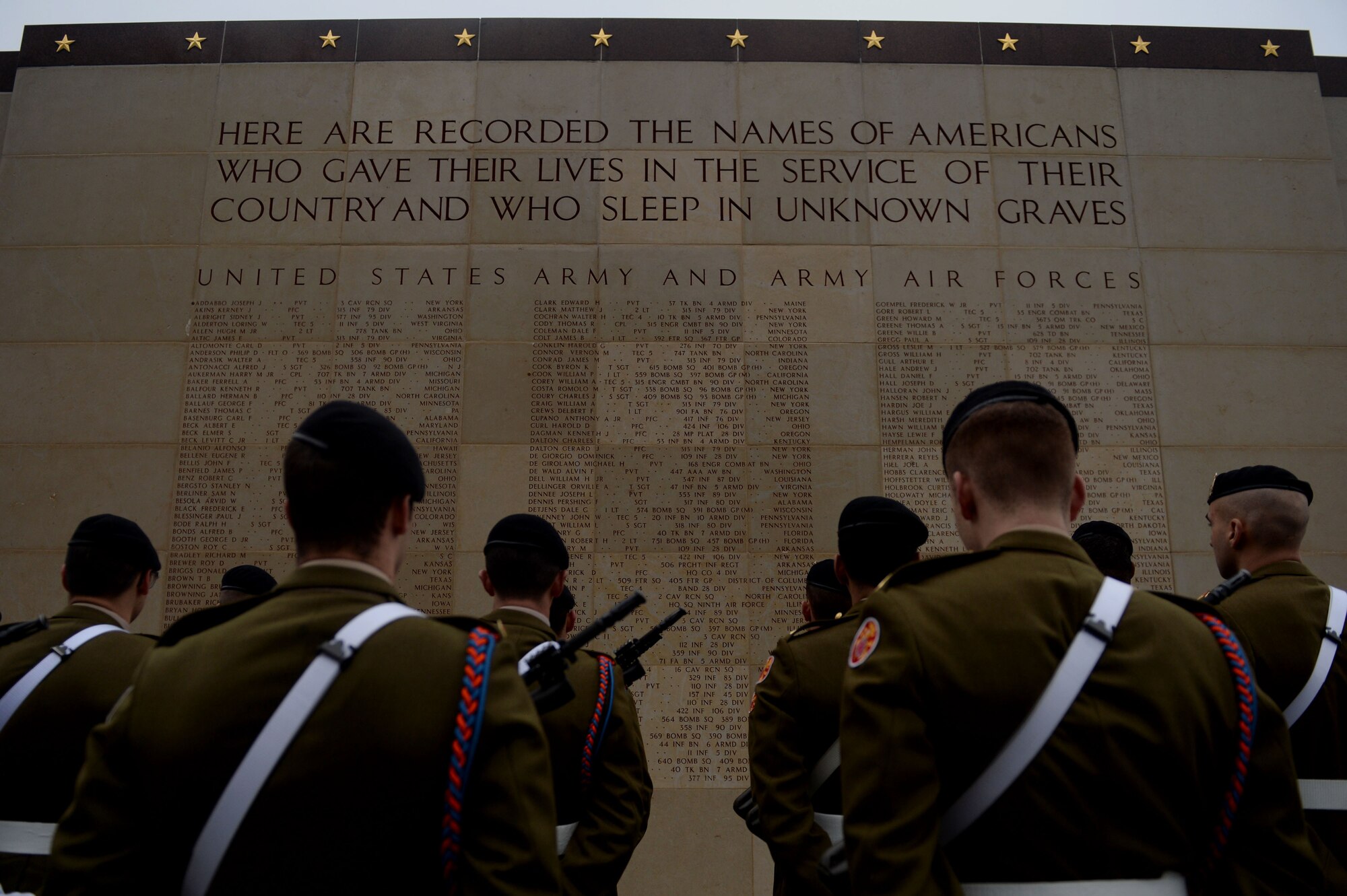Luxembourg Army soldiers stand in formation in front of a wall commemorating fallen American service members before the Battle of the Bulge 70th Anniversary ceremony at the Luxembourg American Military Cemetery in Luxembourg, Dec. 16, 2014. The cemetery holds the bodies of 5,076 U.S. service members, 101 of whom are unknown. (U.S. Air Force photo by Airman 1st Class Timothy Kim/Released)