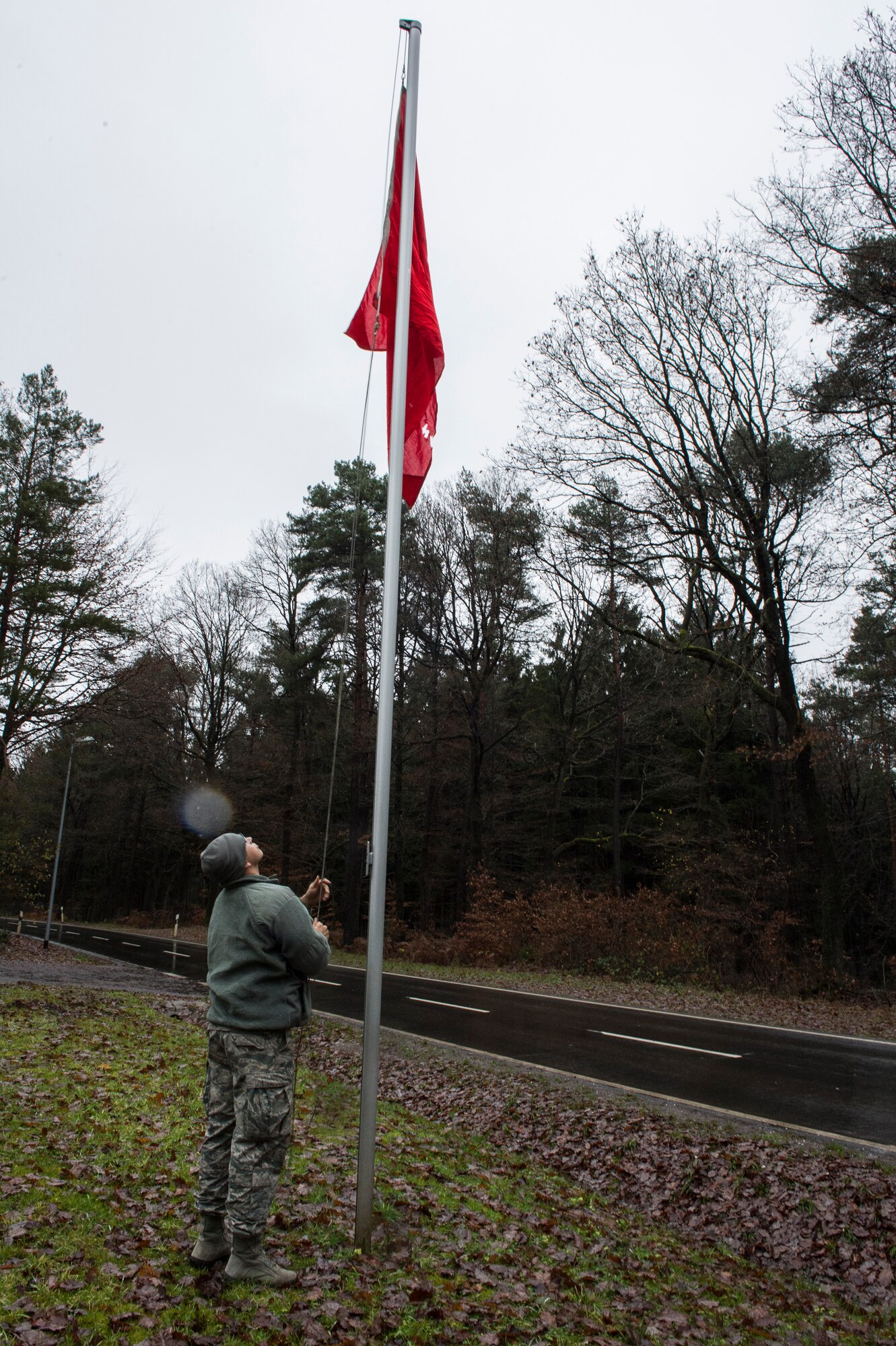 A member of the 52nd Civil Engineer Squadron Explosive Ordnance Disposal flight hoists up a red flag during a suspicious package demolition training session on Spangdahlem Air Base, Germany, Dec. 17, 2014. The flag indicates to drivers, use caution because the EOD members are suing live ammunition or explosives training in the area. (U.S. Air Force photo by Staff Sgt. Christopher Ruano/Released)