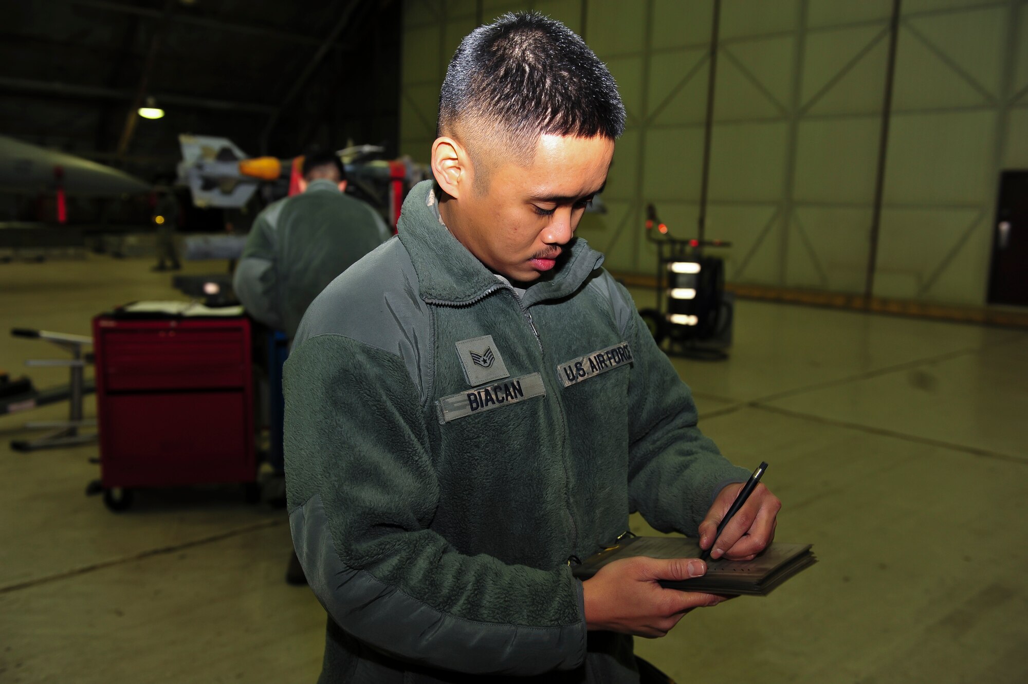 Staff Sgt. Alston Biacan, 51st Maintenance Operations Flight load crew member, fills out a post load checklist during a weapons standardization inspection Dec. 16, 2014, at Osan Air Base, Republic of Korea. Some of the criteria the Airmen have to complete to pass the inspection are loading the munitions in a certain amount of time, maintain proficiency, ensure they have checked of the required steps and safely complete the job. (U.S. Air Force photo by Senior Airman David Owsianka)