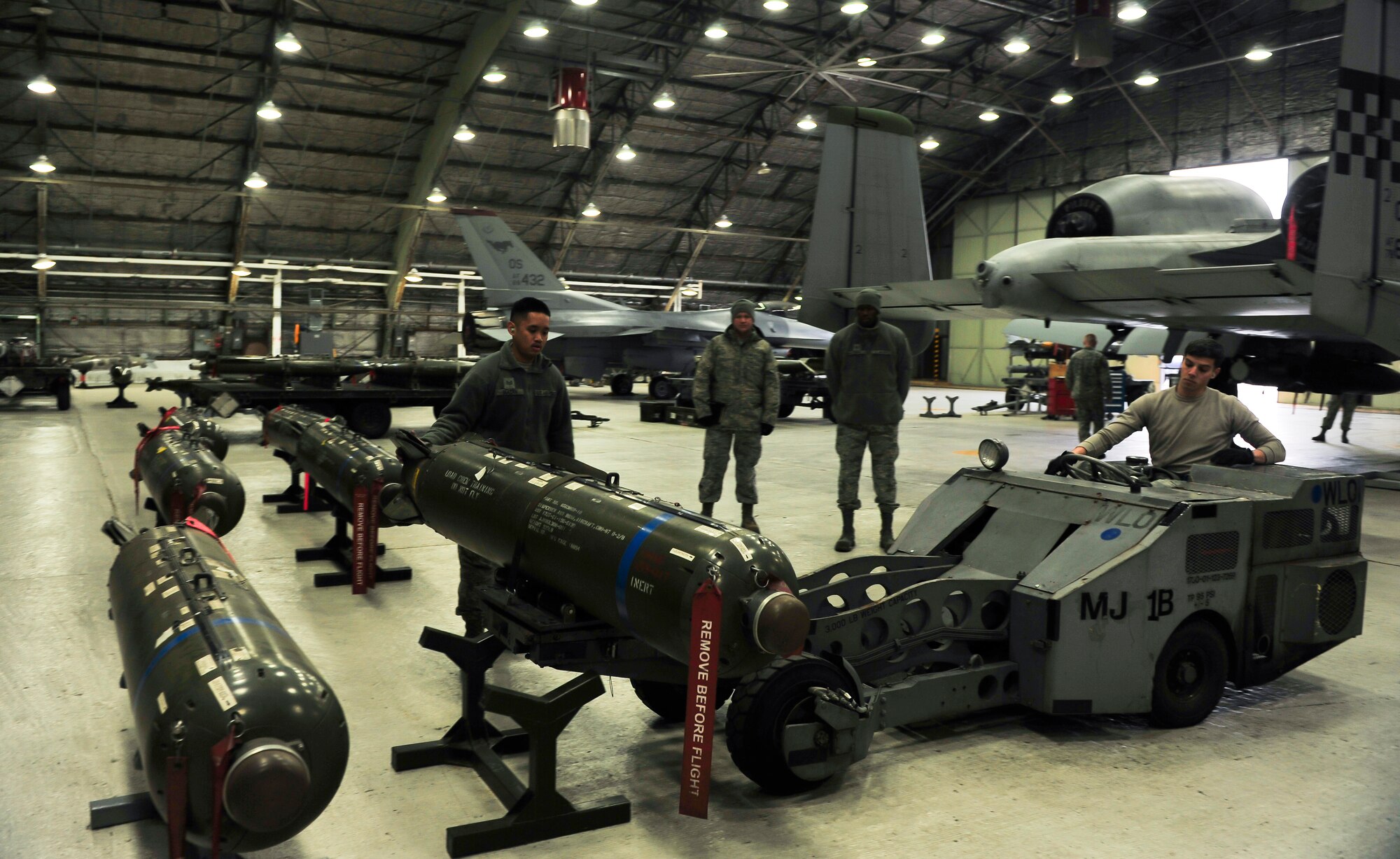 Staff Sgt. Alston Biacan and Senior Airman Anthony Cicchino, 51st Maintenance Operations Flight load crew members, load a bomb onto a MJ-1 vehicle during a weapons standardization inspection Dec. 16, 2014, at Osan Air Base, Republic of Korea. The load crew members are required to be recertified on the 15 different munitions every 30-days. (U.S. Air Force photo by Senior Airman David Owsianka)