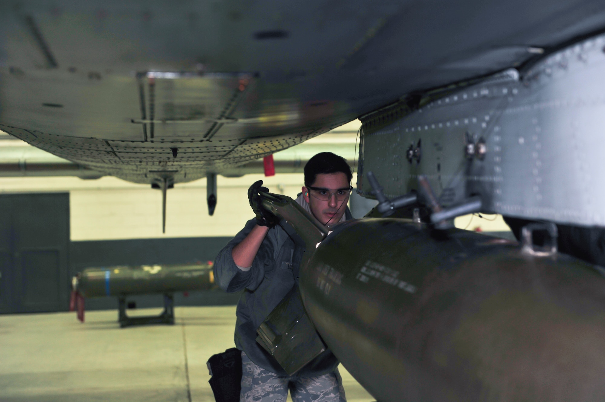 Senior Airman Dylan Logsdon, 51st Maintenance Operations Flight load crew member, ensures the bomb is lined up with the bomb rack during a weapons standardization inspection Dec. 16, 2014, at Osan Air Base, Republic of Korea. Some of the criteria the Airmen have to complete to pass the inspection are loading the munitions in a certain amount of time, maintain proficiency, ensure they have checked of the required steps and safely complete the job. (U.S. Air Force photo by Senior Airman David Owsianka)