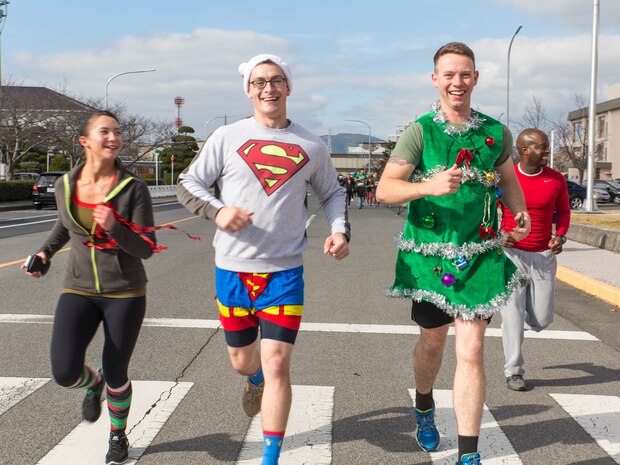 Left to right, Cpl. Jessica Quezada, a combat correspondent, Lance Cpl. Mark Adams, a combat photographer, and Cpl. Mitchell Flowers, a combat camera production specialist, participate in the Jingle Bell Jog, Dec. 19, 2014, aboard Marine Corps Air Station Iwakuni, Japan. The Marines are with Headquarters and Headquarters Squadron. Marine Corps Community Services hosted the event to help raise morale during the holiday season. The 1.5km event had more than 1,400 participants from various units aboard station. 