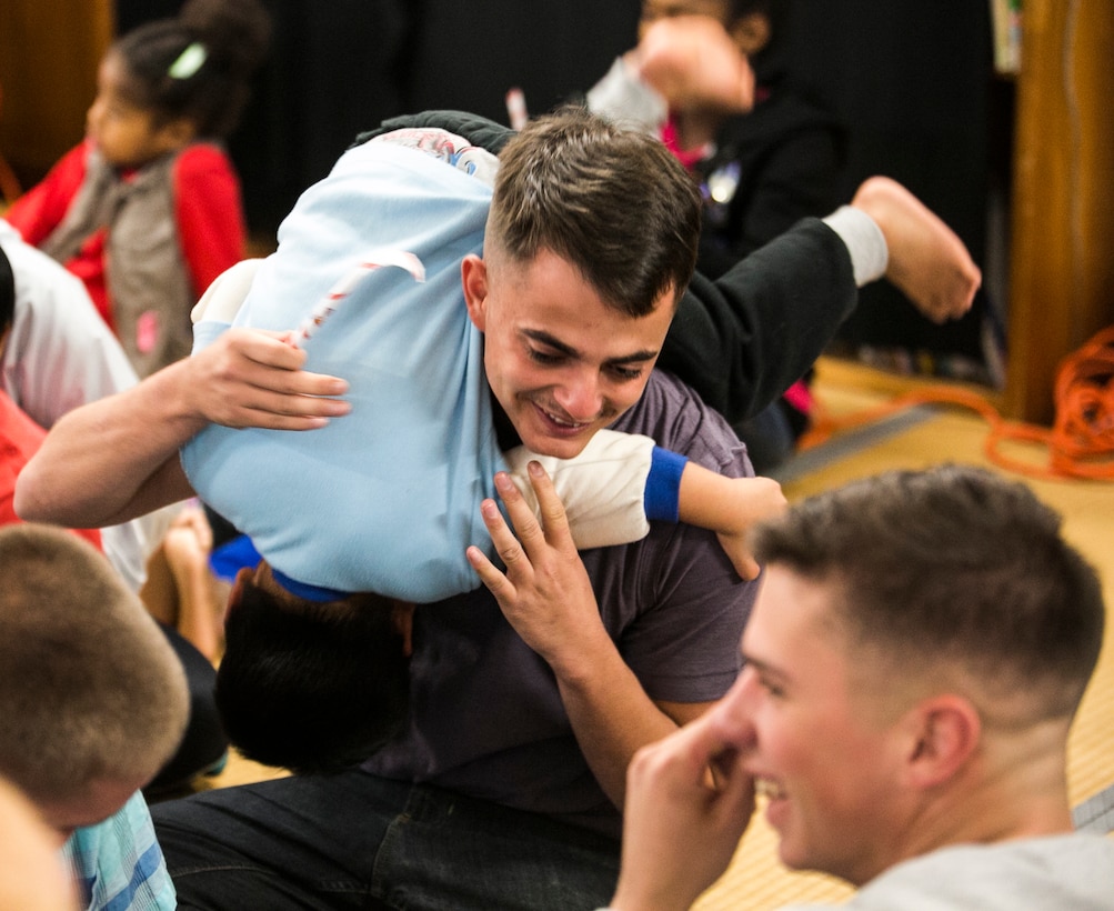 Lance Cpl. Devry D. Faddis plays with children during a Christmas party Dec. 15 at Nagomi Nursing Home for Children in Nago. The children were taught how to make candy cane designs using paper. The Marines handed out gifts and sang Christmas songs with the children. Faddis is an assault amphibious vehicle crewman with Combat Assault Battalion, 3rd Marine Division, III Marine Expeditionary Force.