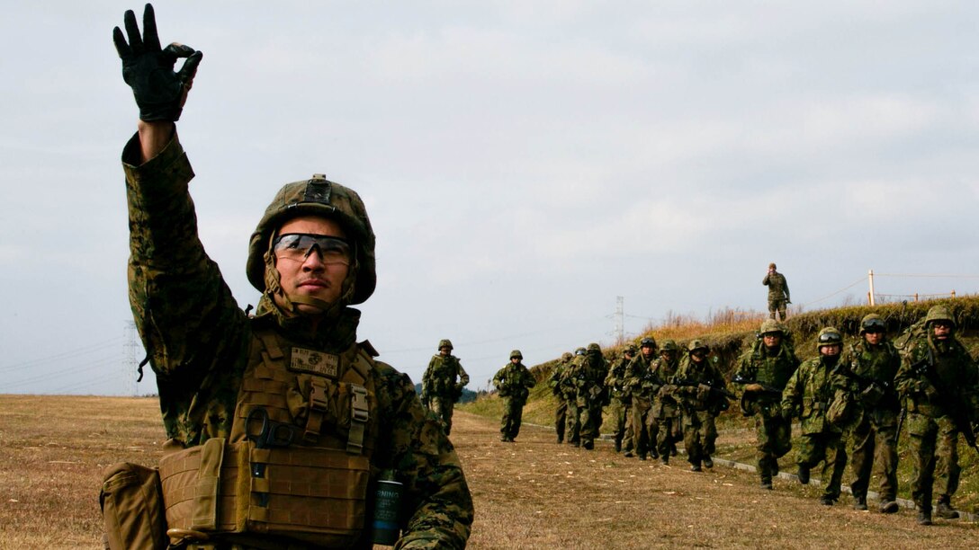 U.S. Marine Lance Cpl. Salvador Waterstradt signals an incoming MV-22B Osprey, Dec. 7, during Forest Light 15-1 at the Oyanohara Training Area in Yamato, Kumamoto prefecture, Japan. Forest Light is a routine, semi-annual exercise designed to enhance the U.S. and Japan military partnership, solidify regional security agreements and improve individual and unit-level skills. Waterstradt, from Philadelphia, Pennsylvania, is a rifleman with 2nd Battalion, 9th Marine Regiment, currently assigned to 4th Marine Regiment, 3rd Marine Division, III Marine Expeditionary Force, under the unit deployment program. 