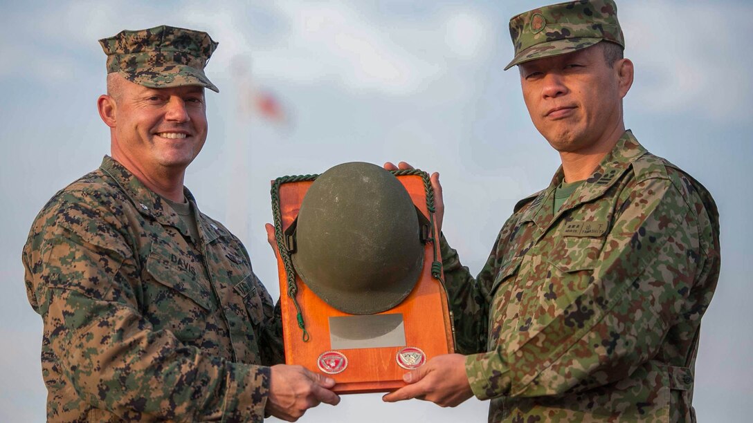 U.S. Marine Lt. Col. Nicholas Davis, left, presents Japan Ground Self-Defense Force Col. Hiroji Yamashita with a plaque, Dec. 12, during the closing ceremony for Forest Light 15-1 at Camp Kita Kumamoto in Kumamoto, Kumamoto prefecture, Japan. Forest Light is a routine, semi-annual exercise designed to enhance the U.S. and Japan military partnership, solidify regional security agreements and improve individual and unit-level skills. Davis is the commanding officer of 2nd Battalion, 9th Marine Regiment, currently assigned to 4th Marine Regiment, 3rd Marine Division, III Marine Expeditionary Force, under the unit deployment program. Yamashita is the commanding officer of the 42nd Regiment, 8th Division, Western Army, JGSDF. (U.S. Marine Corps photo by Cpl. Drew Tech/Released)