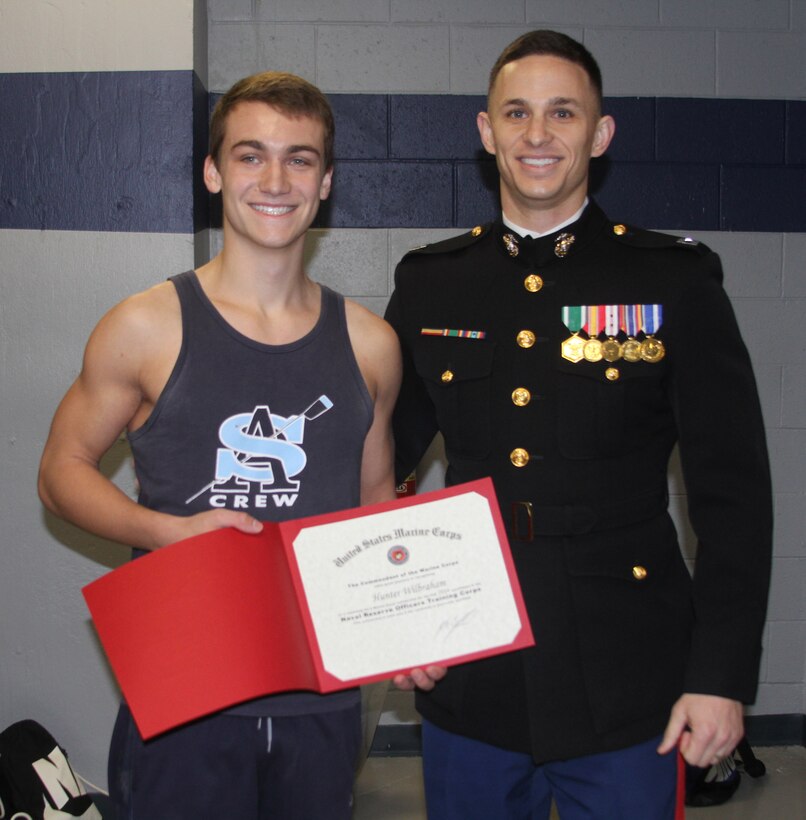 Hunter Wilbraham, a senior at St. Augistine Preparatory School, receives a certificate for earning the NROTC-Marine Option Scholarship from Capt. Zachary Smith, at St. Augustine Preparatory School in Richlands, N.J., Dec. 19, 2014. 