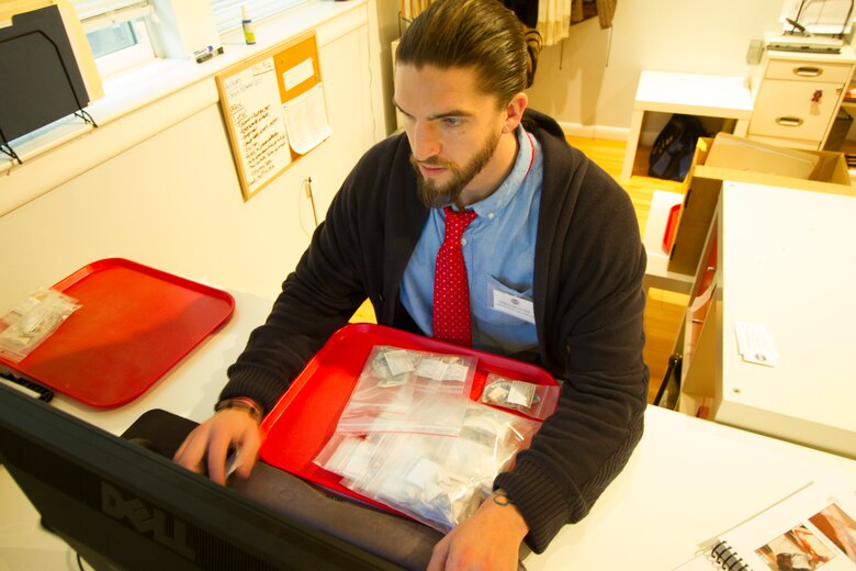 ALEXANDRIA, Va. -- Greg Boster, a Veterans Curation Program laboratory technician, enters data into a computer Dec. 3, 2014 about artifacts recovered from Fort Norfolk in the late 1970s. Boster is an Army veteran and will spend five months in the curation program learning professional archiving techniques, as well as interview and resume-writing skills as he makes the transition to civilian life. (U.S. Army photo/Patrick Bloodgood)